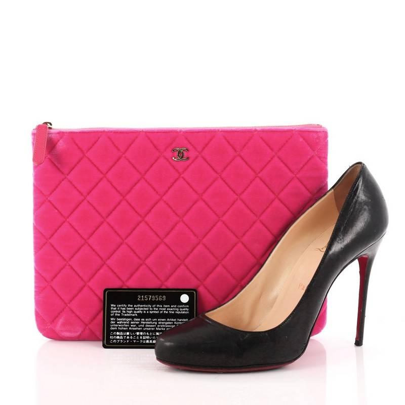 This authentic Chanel O Case Clutch Quilted Velvet Medium adds a touch of elegance to your everyday outfits. Crafted from neon pink quilted velvet, this chic clutch features a CC logo on the front and gold-tone hardware accents. Its zip closure