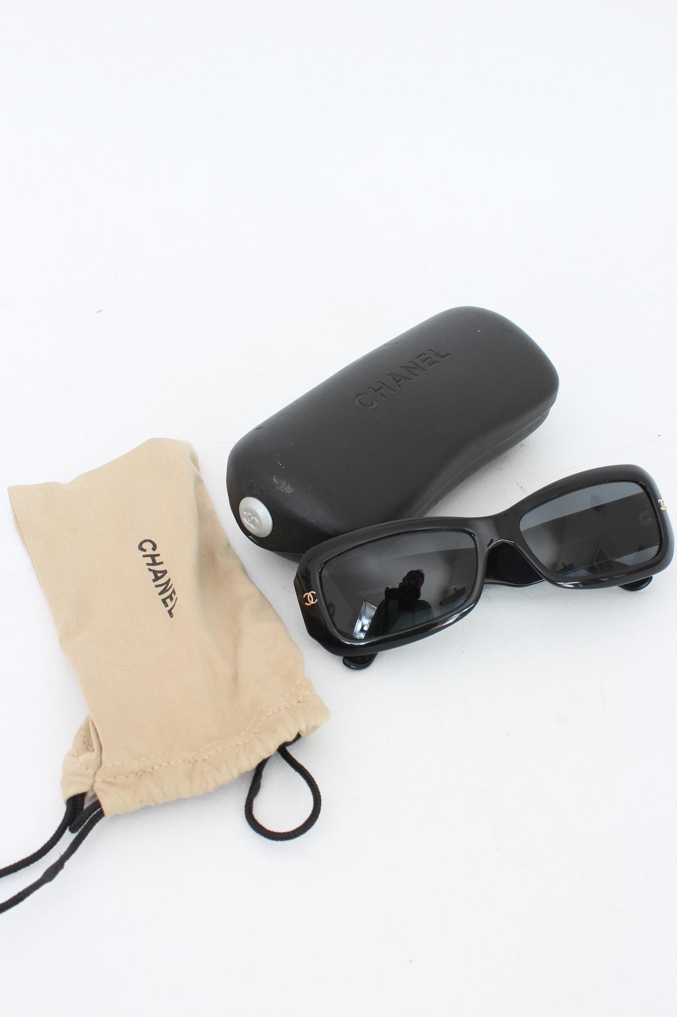 Chanel occhiali da sole vintage anni 2000. Colore nero con dettagli dorati sulle aste effetto trapuntato. Lente nera rettangolare. Presenti la dustbag e la custodia originale.

Codice: 5099 - 56.15.135

Lunghezza asta: 130 mm
Lunghezza lente: 50 mm