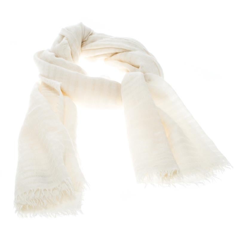 Get a style upgrade on your basic outfits with this off-white scarf from Chanel. Cut from a blend of cashmere and silk, the scarf is finished with a fringed hem. This versatile scarf is an asset, as it can style up almost all your entire