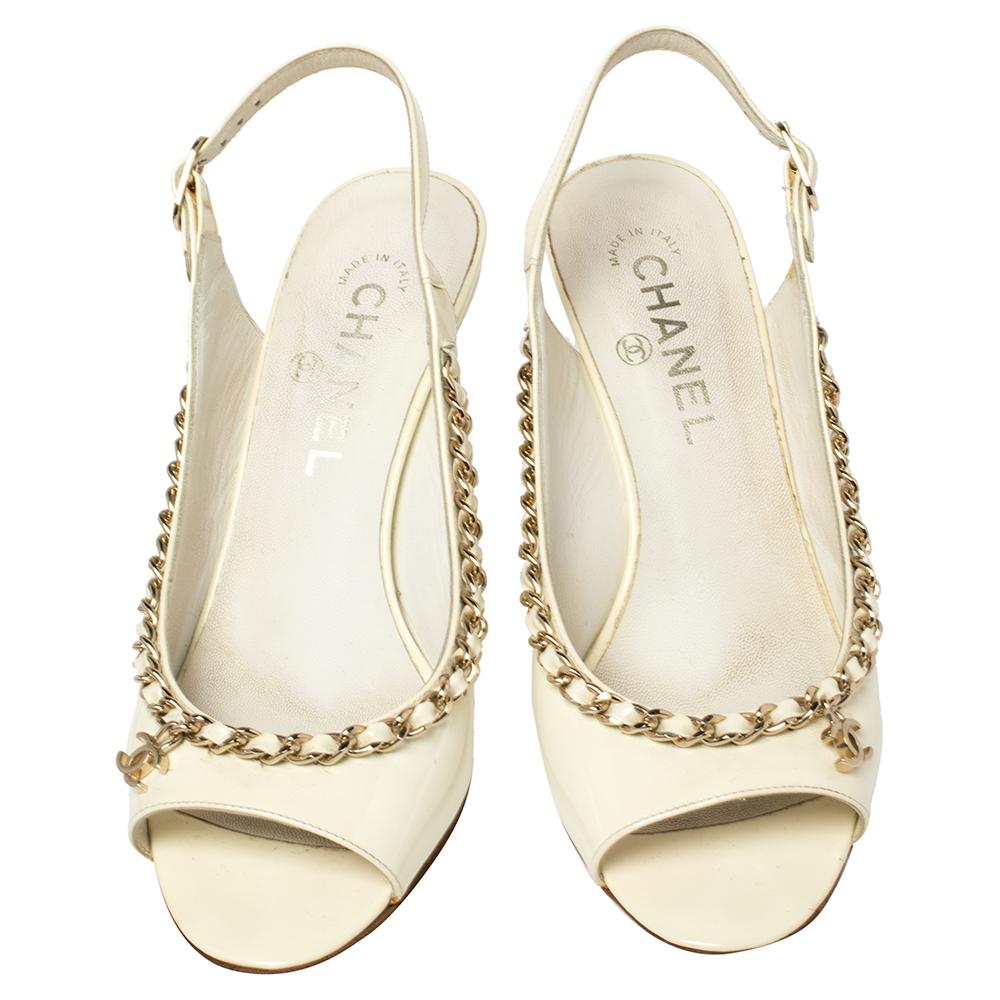 Transform into a style diva when you are wearing these stunning Chanel sandals. Crafted from quality patent leather, they come in a classic shade of off-white. They are styled with open toes, signature chain-link detailing along the toplines, CC