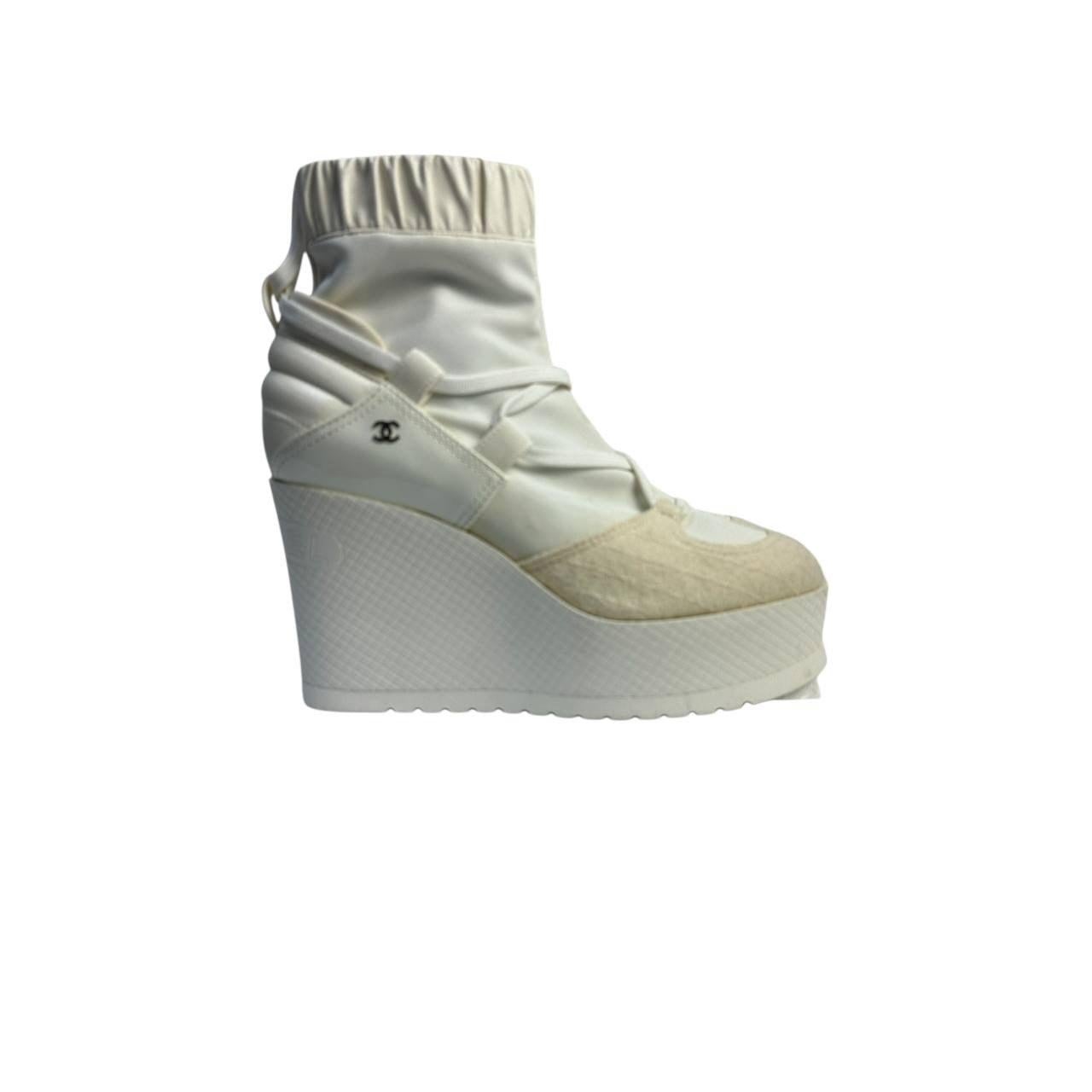 Step out in style with these chic Chanel wedge boots! Crafted from a blend of neoprene, off-white patent leather, and fabric, these boots offer a modern and fashionable look. The lace-up design adds a touch of elegance, while the comfortable insoles