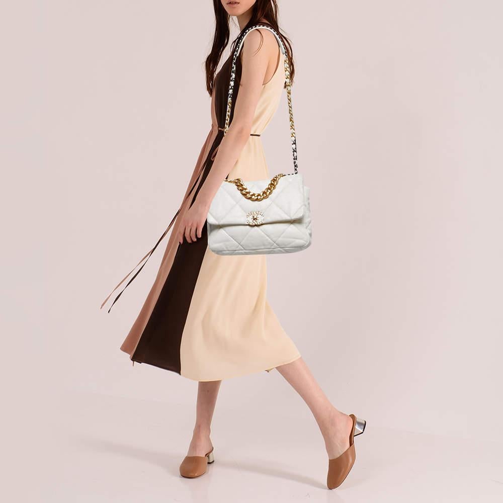 First unveiled in the Chanel Fall 2019 collection, the Chanel 19 bag is named after the year of its release, just like the Chanel 2.55. In design, the bag has exaggerated quilting and hardware in two tones. This version in off-white is made from