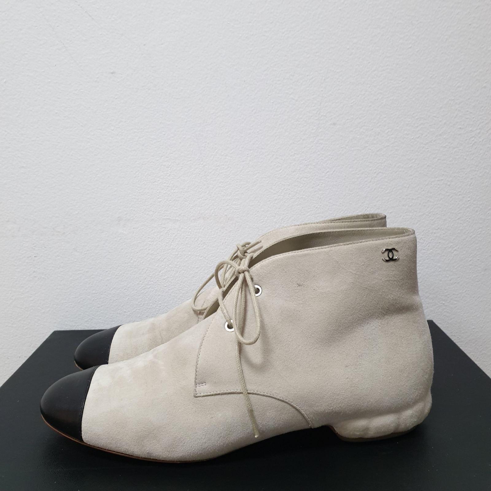 Off-white neutral suede with black leather cap-toe
Interlocking CC logo at side
Round toe
Lace-up closure at uppers
Sz. 39
No box, no dust bag