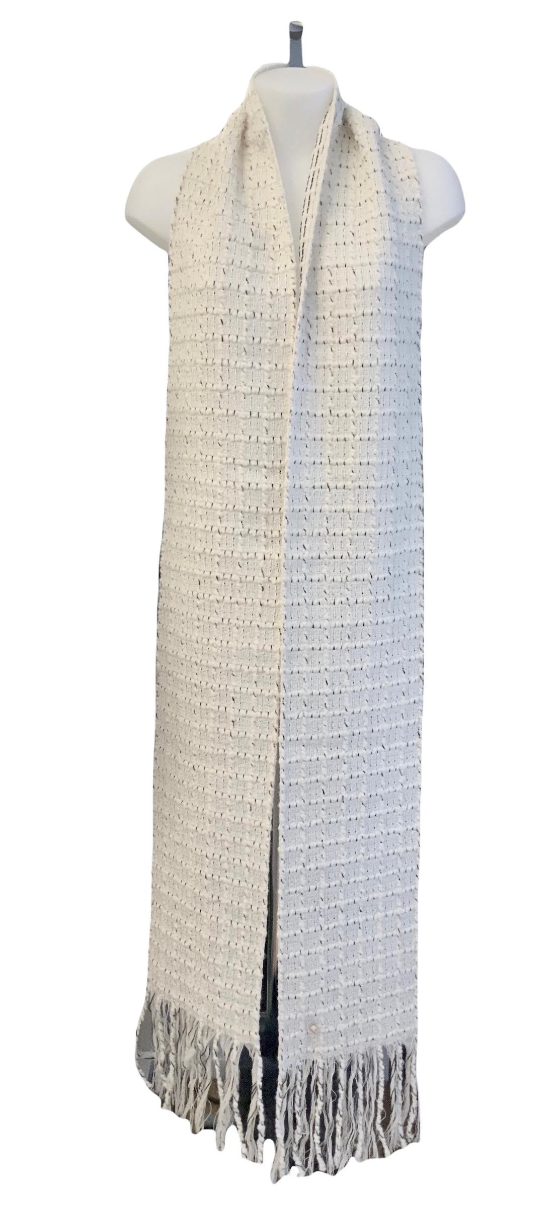Rare long stole from the house of Chanel. It is made of a beautiful off-white wool tweed with black thread details.

Year: 2017
Material: 90% wool, 4% nylon, 3% polyester, 3% acrylic
Color: off-white
Measurements: 
Length: 260 cms - approx. 100