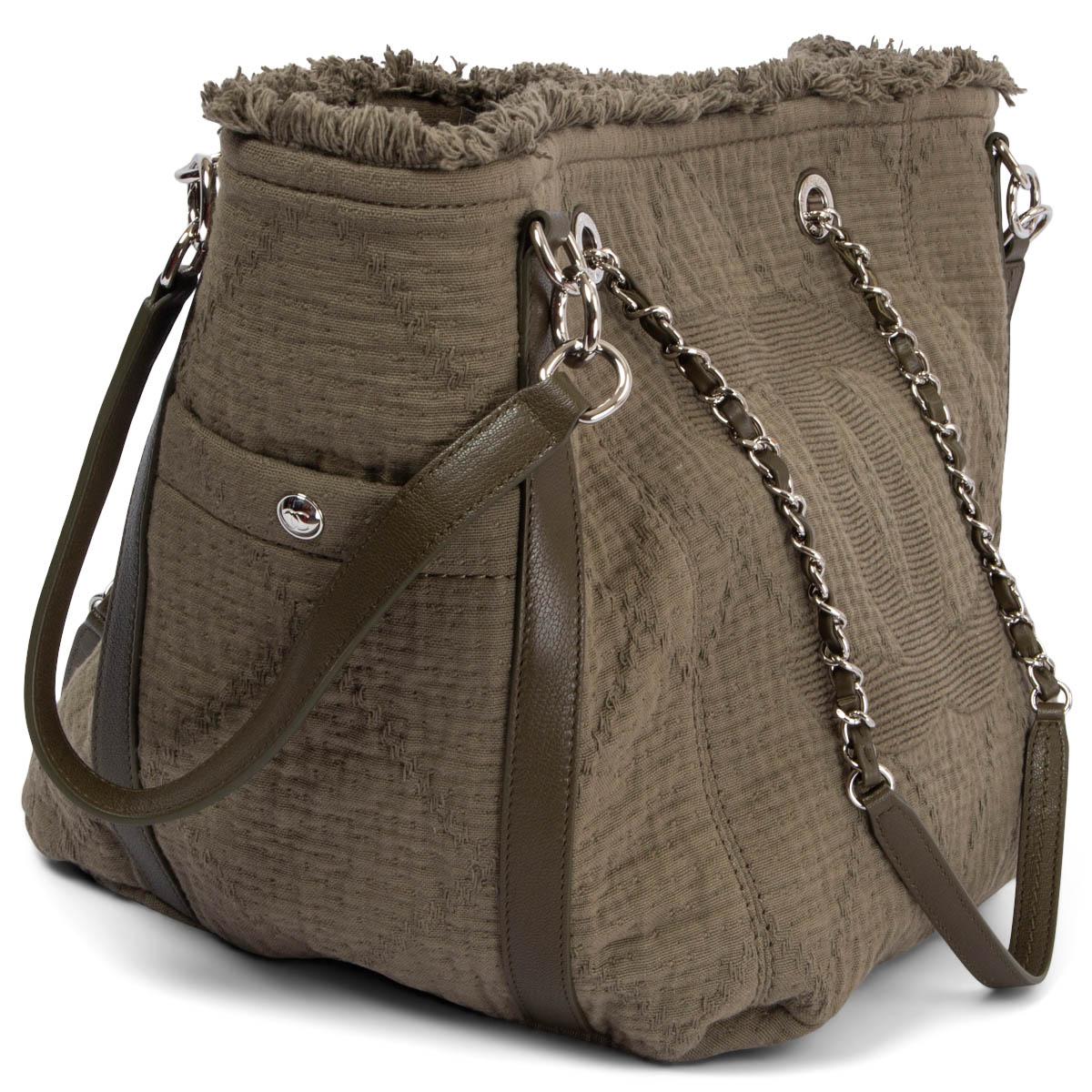 100% authentic Chanel fringed tote bag in drab olive double face cotton canvas featuring silver-tone hardware. Can be worn two different ways and comes with detachable side shoulder-straps and two side pockets. Opens with a magnetic button and is