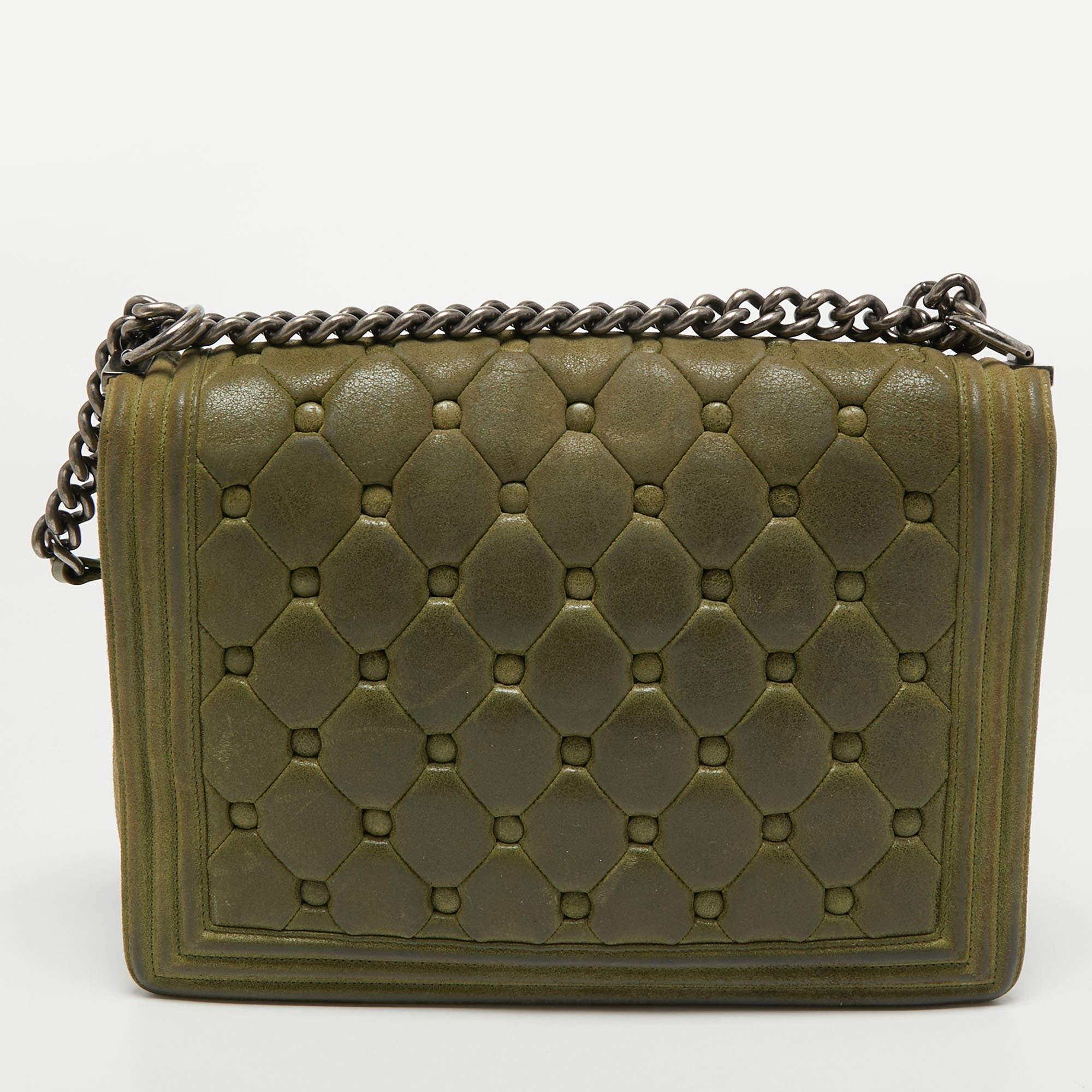 Introduced as a part of the Chanel Fall/Winter collection of 2011, the Boy bag embodies an alluring appeal and is complemented with exquisite details. This olive green creation is meticulously crafted from quilted suede with side paneling and