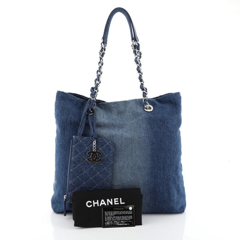 This Chanel Open Tote Denim Medium, crafted from blue denim, features woven-in denim chain straps and silver-tone hardware. It opens to a blue denim interior. Hologram sticker reads: 27551375. 

Estimated Retail Price: $3,200
Condition: Excellent.