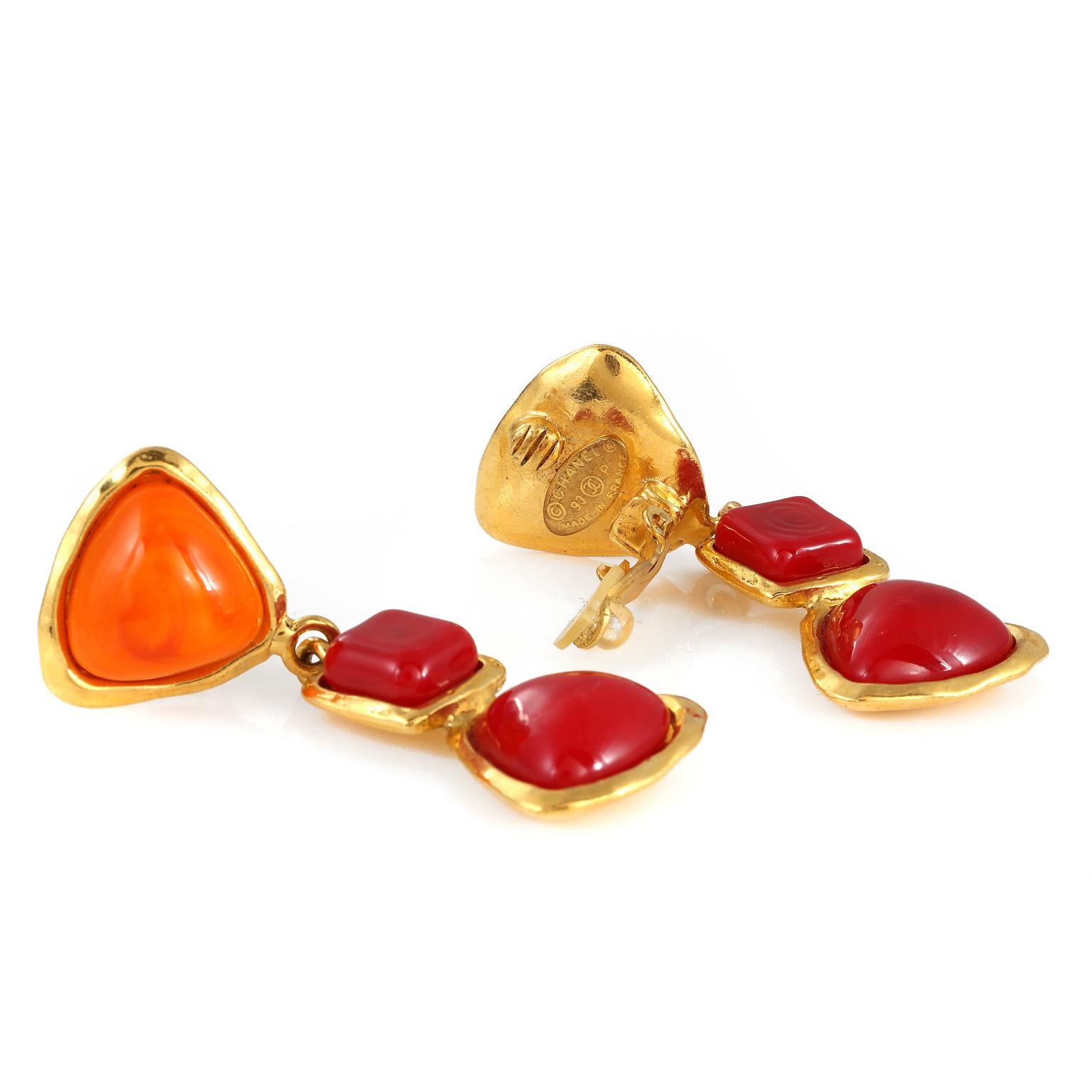 These authentic Chanel Orange and Red Gripoix Dangle Earrings are in exceptionally good vintage condition from the Spring 1993 collection.  Opaque orange and red Gripoix glass stones are set in gold tone metal.  Two red stones dangle from an orange