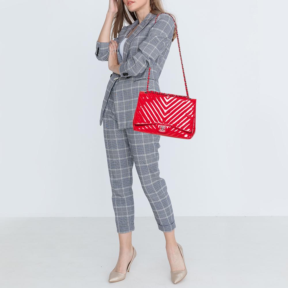Mit dieser Kreation bringen wir die kultige Classic Flap Bag von Chanel in Ihren Kleiderschrank. Die aus Lackleder gefertigte Tasche ist mit einem Chevron-Steppmuster überzogen und trägt das Signaturetikett auf der Lederinnenseite sowie den kultigen