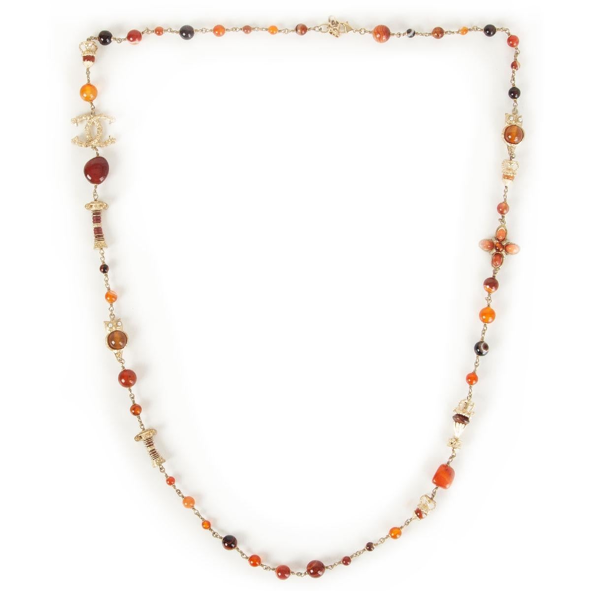 authentic Chanel Paris - Greece necklace in rust, orange, burgundy and honey colored faux stones embellished with CC logo an owl and temple pillars in light-gold metal. Has been worn and is in excellent condition. 

Length 56cm (21.8in)
Hardware