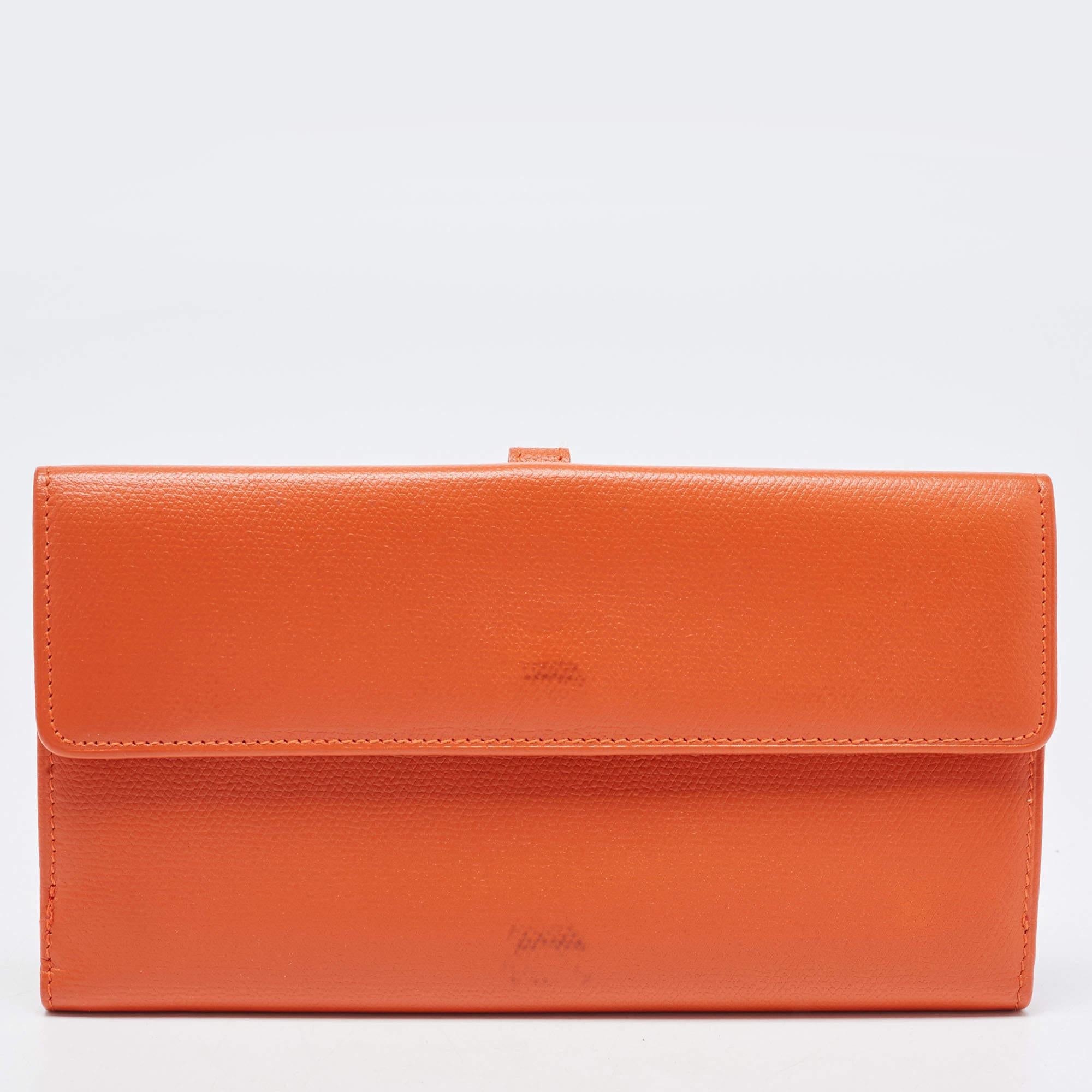This Chanel long wallet is conveniently designed for everyday use. Crafted from orange leather, the wallet has a fold closure that opens to reveal slip compartments and multiple card slots, for you to neatly arrange your cash and cards. This stylish