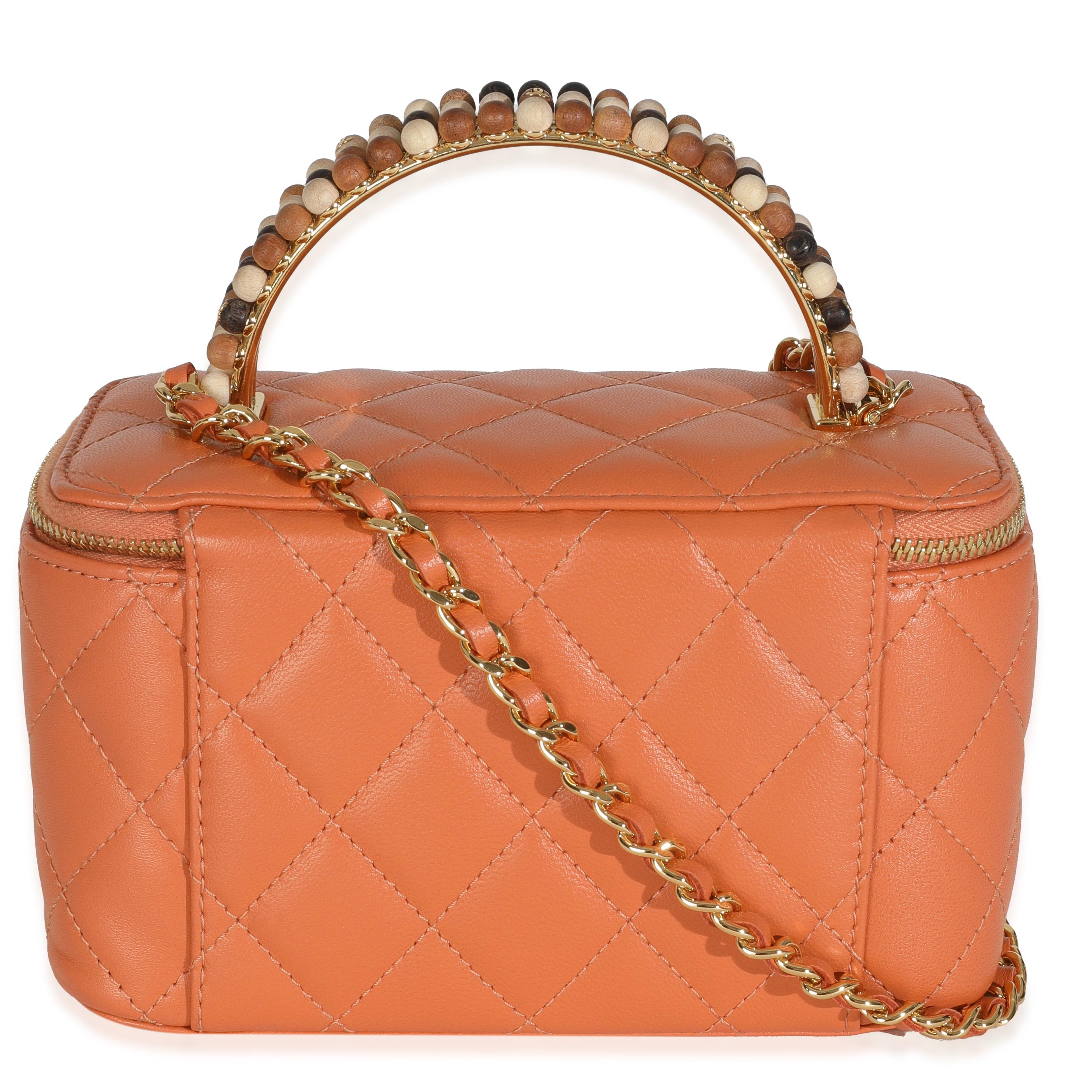 Titre du listing : Chanel - Petit vanity case avec chaîne en cuir d'agneau matelassé orange et perles
SKU : 147733
Condit : Usagé 
Condit : Intrinsèquement Chanel, le sac moyen à poignée supérieure Coco porte le nom de la fondatrice de la Maison.