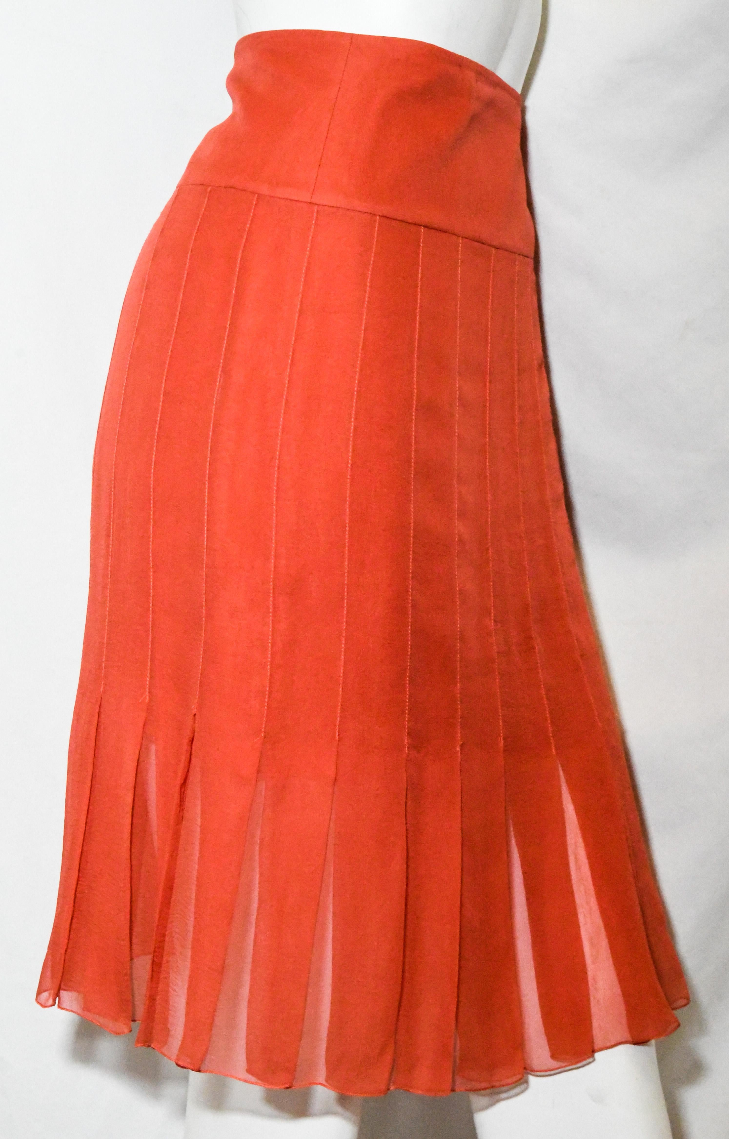 Chanel orange silk sheer chiffon pleated skirt lined to above  the knee with unlined pleats, at the hem.   Orange pleated silk skirt from the 04 spring collection. Wide waistband with three logo Chanel CC buttons closure.   Skirt lined in pink semi