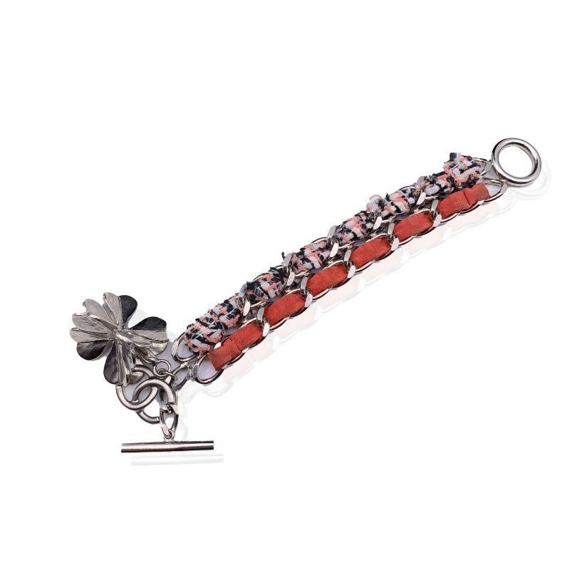 Lovely Chanel bracelet from the 2014 Spring collection It is features silver metal chain with interwoven orange/salmon suede and pink and white tweed ribbon. Silver metal oversized dangle clover charm at the end of the bracelet. Toogle closure.