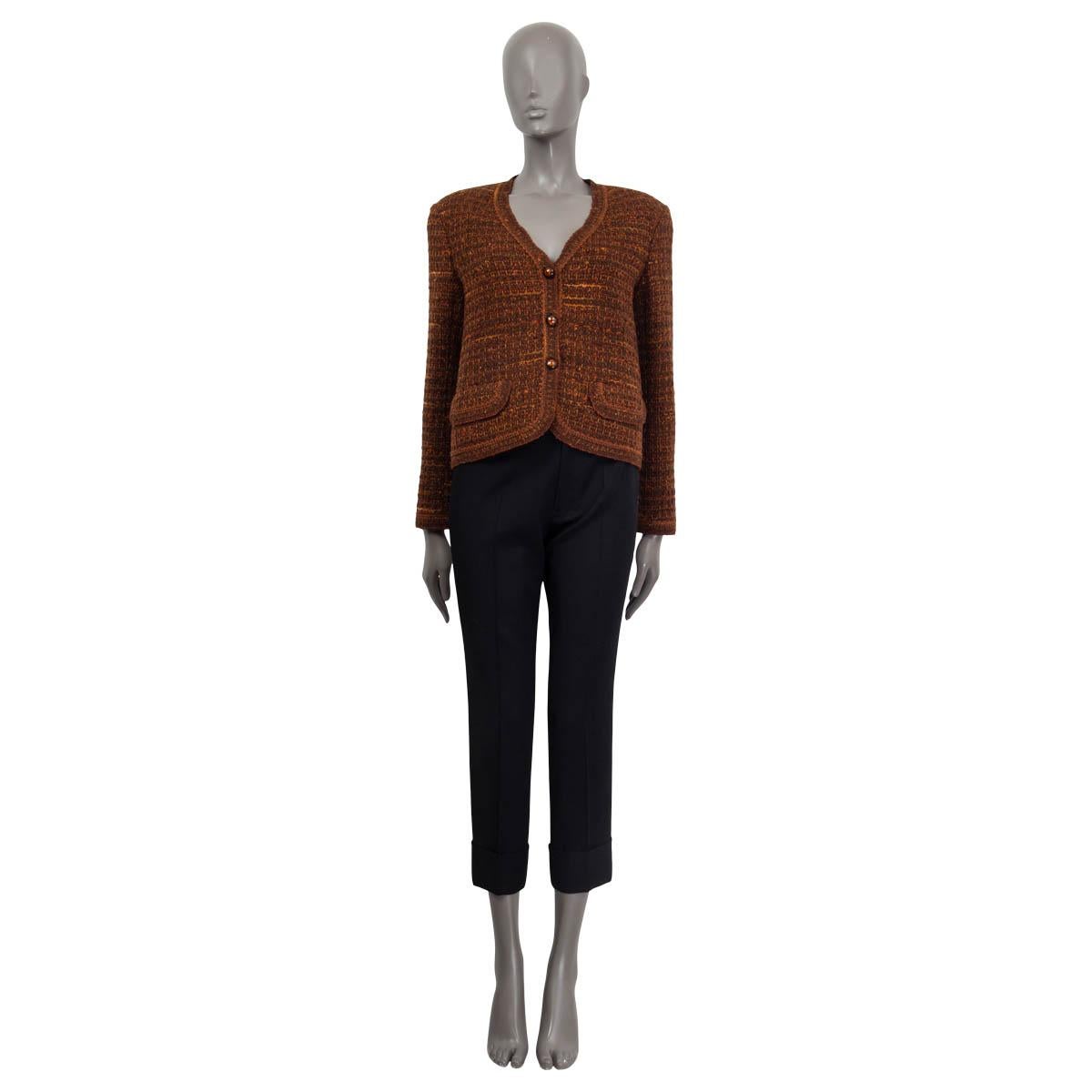 100% authentic Chanel Fall/Winter 1998 v-neck blazer in brown and orange wool (95%) and acrylic (5%). Features padded shoulders, two flap pockets on the front and buttoned cuffs. Opens with three buttons on the front. Sleeves lined in brown silk