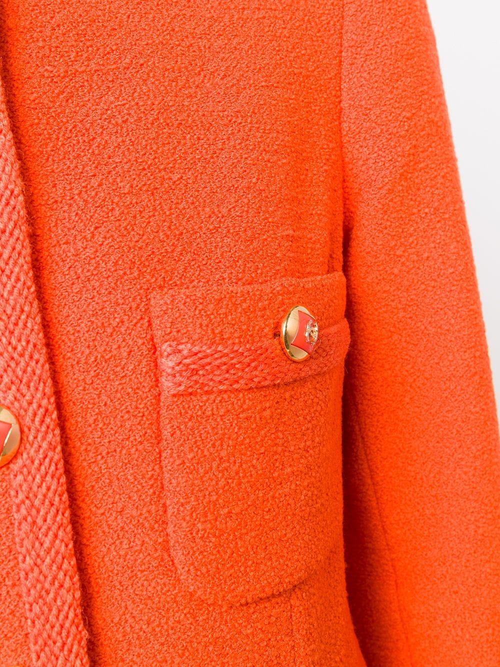Expertly cut and crafted in France from pure wool in a vibrant shade of tangerine orange, this pre-owned, long-sleeved jacket from Chanel showcases the modern design of crew neck collar and a textured pattern throughout and a pure silk lining. The