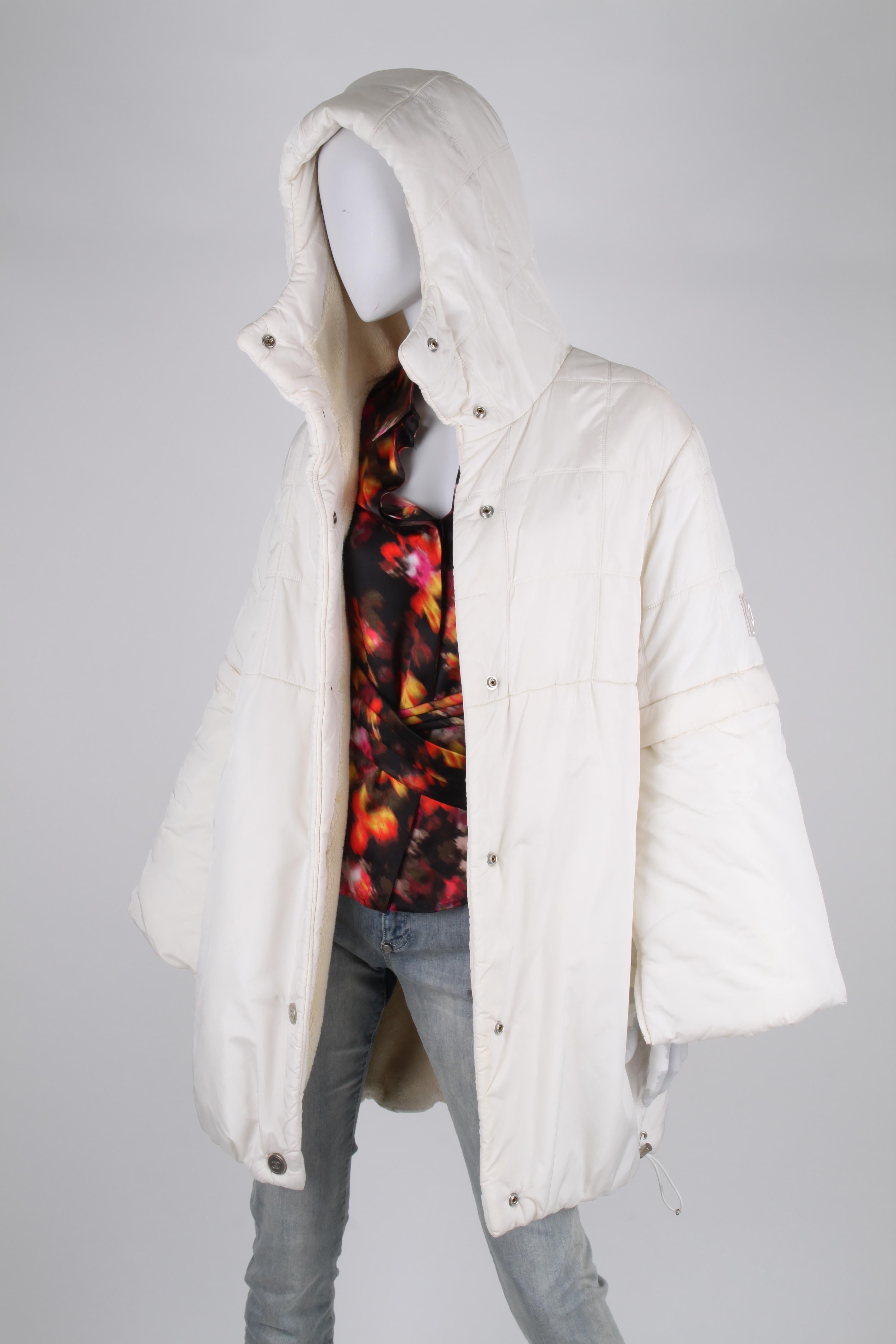 This wonderful white coat is from the Sports Line by Chanel, autumn collection 2000.

Front closure with large matte silver-tone push buttons embellished with the CC logo. Has more than hip length, welt pockets, a hood and extra wide sleeves with a