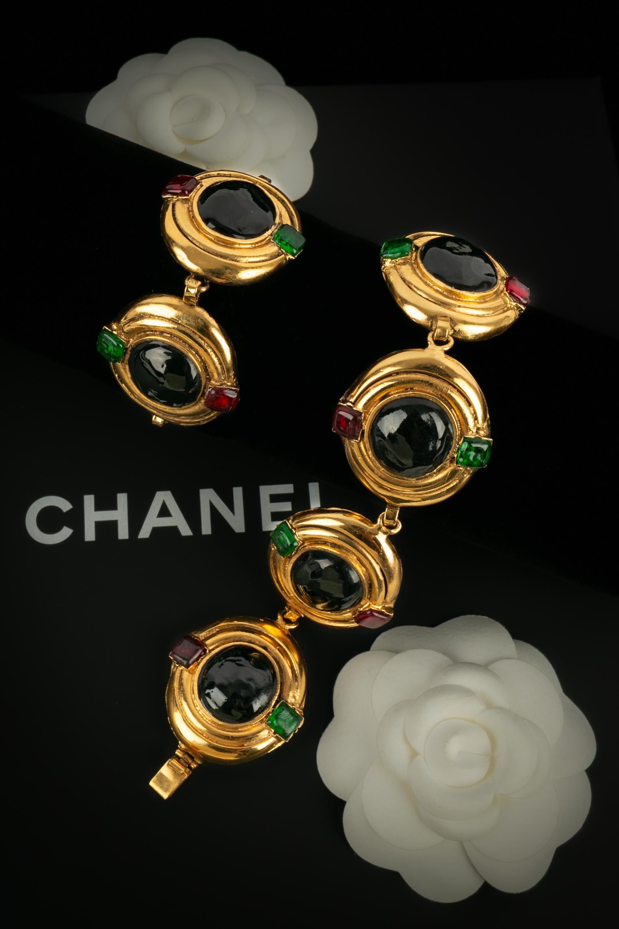 CHANEL - (Fabriqué en France) Paire de bracelets en métal doré avec pâte de verre. Une Collection des années 1980. Seul un bracelet porte une signature.

Condit :
Très bon état.

Dimensions :
Longueur : 17 cm - Largeur : 3,5 cm

SKU:BRAB34


