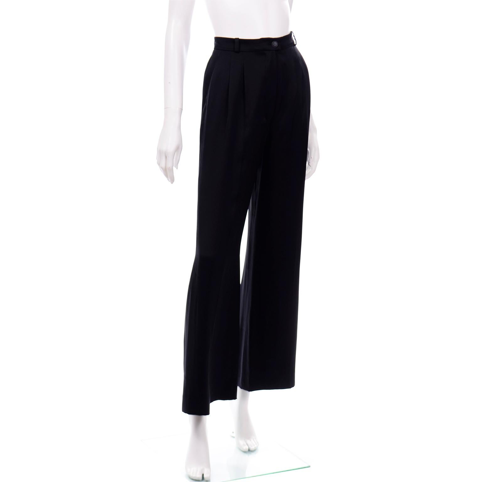 These are really elegant black silk Chanel pants from the Spring 2002 collection. The pants are high waisted and have two pleats on the front and a center fold down the leg. The waistband really slim and has small belt loops and a center CC monogram