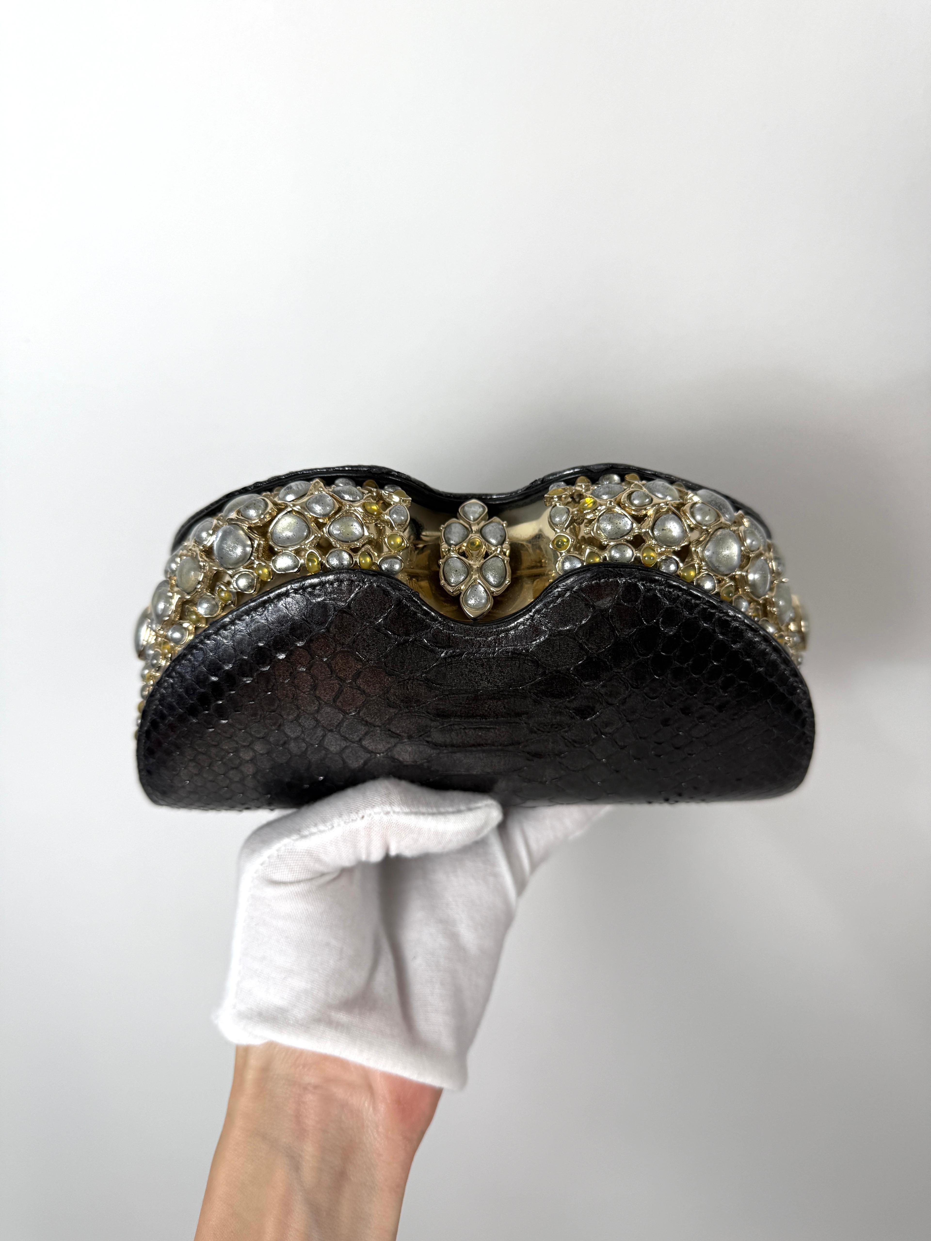 Extremely rare and luxurious, this Chanel clutch is from the 2013 Paris-Bombay Métiers d’Art collection — a masterpiece that blends opulence with exotic craftsmanship.

Crafted from genuine black python, this structured clutch features an ornate