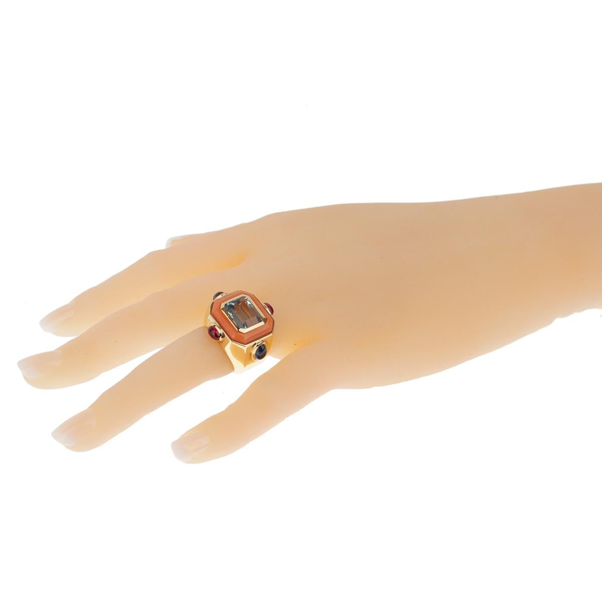 A fun and fashionable Chanel cocktail ring that features an emerald cut topaz and carved coral, all of which are set in 18k Chanel yellow gold. 

Size 5 
Width: 1.05