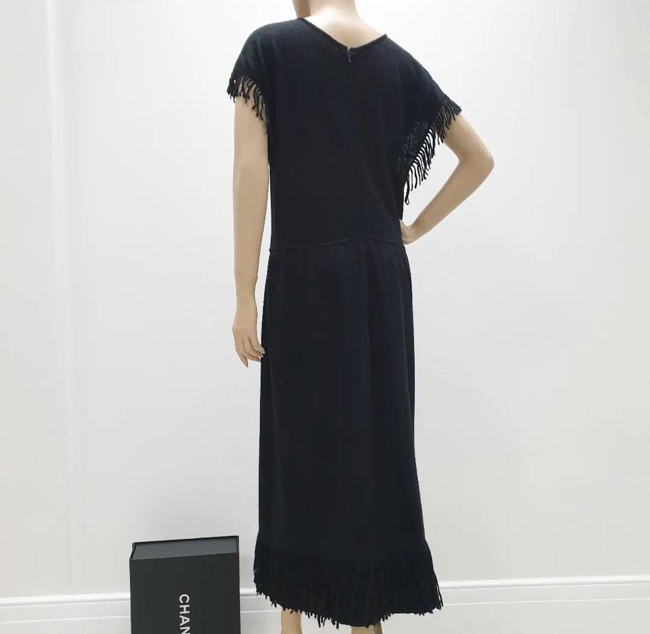Black Chanel mohair and cashmere blend dress with crew neck, interlocking CC logo placard at waist, fringe trim throughout and concealed zip closure at back.

Beautiful Chanel Black knit dress with fringes on the short sleeves and the bottom of the