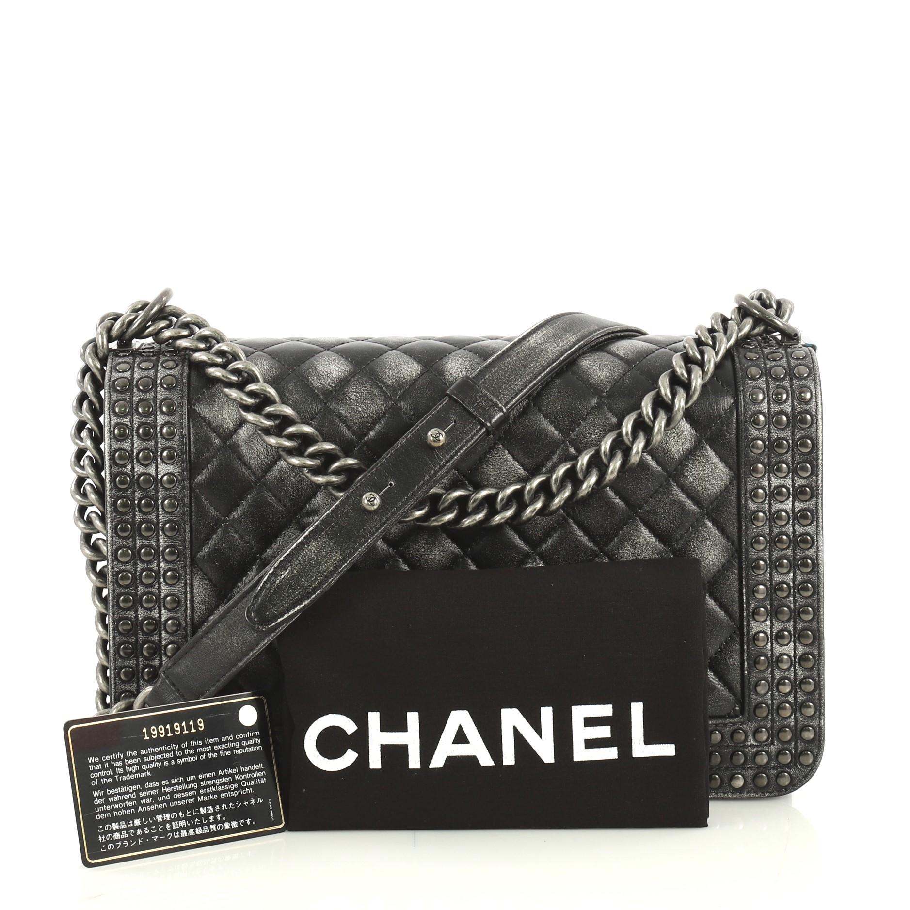 This Chanel Paris-Dallas Boy Flap Bag Quilted Studded Distressed Calfskin New Medium, crafted from black and gray studded distressed calfskin, features chain link strap with shoulder pad, studs detailing, and aged silver-tone hardware. Its CC Boy