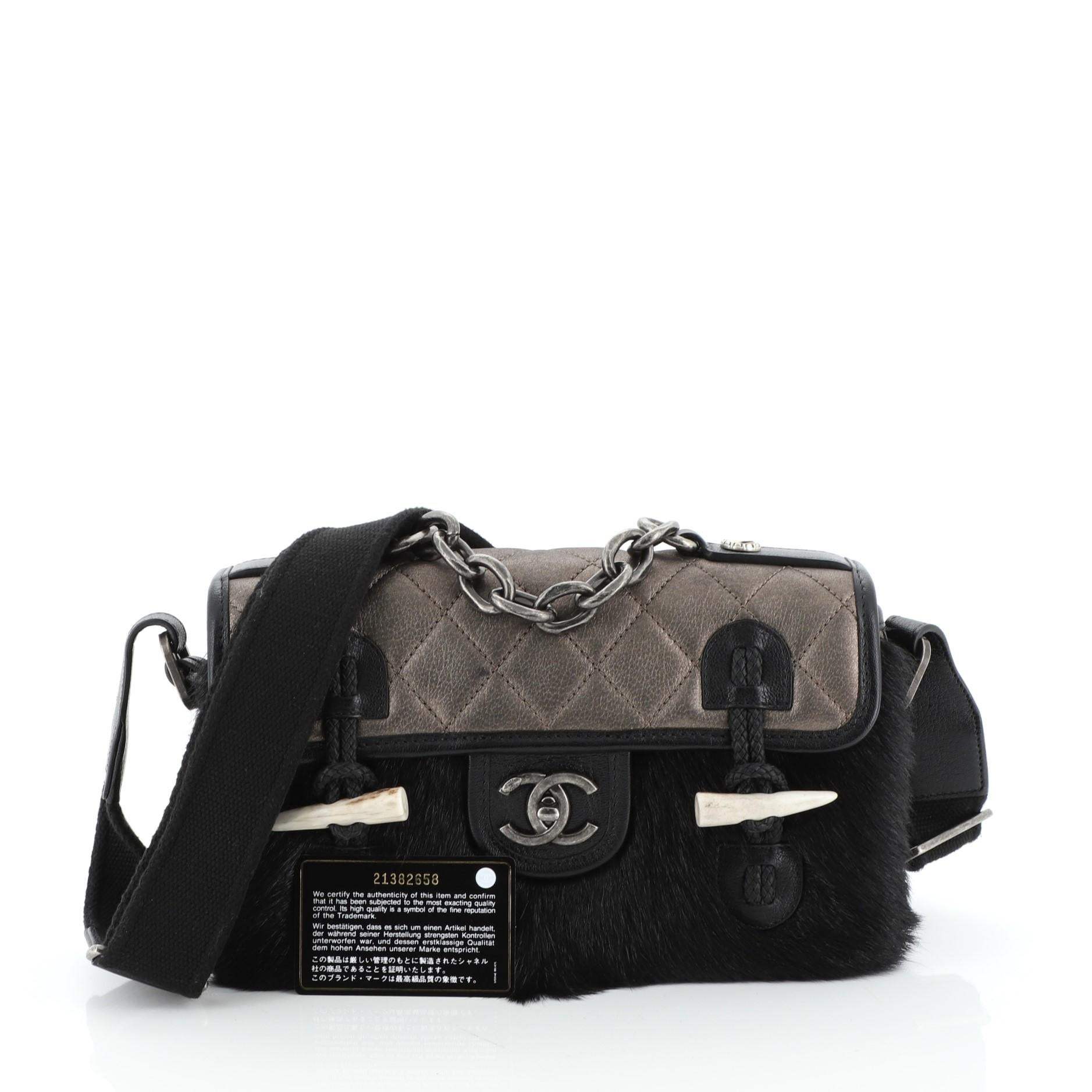 This Chanel Paris-Dallas Cowboy Messenger Bag Quilted Calfskin and Fur Small, crafted from gold quilted calfskin and black fur, features an adjustable strap, frontal flap, and gunmetal-tone hardware. Its CC turn-lock closure opens to a red fabric