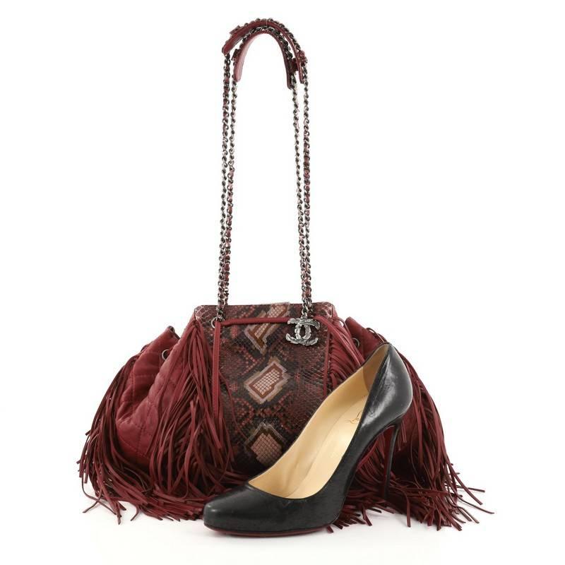 This authentic Chanel Paris-Dallas Drawstring Fringe Shoulder Bag Python and Leather Large mixes avant-garde Parisian sophistication with a touch of western Americana styling. Crafted in genuine burgundy python skin and quilted lambskin leather with