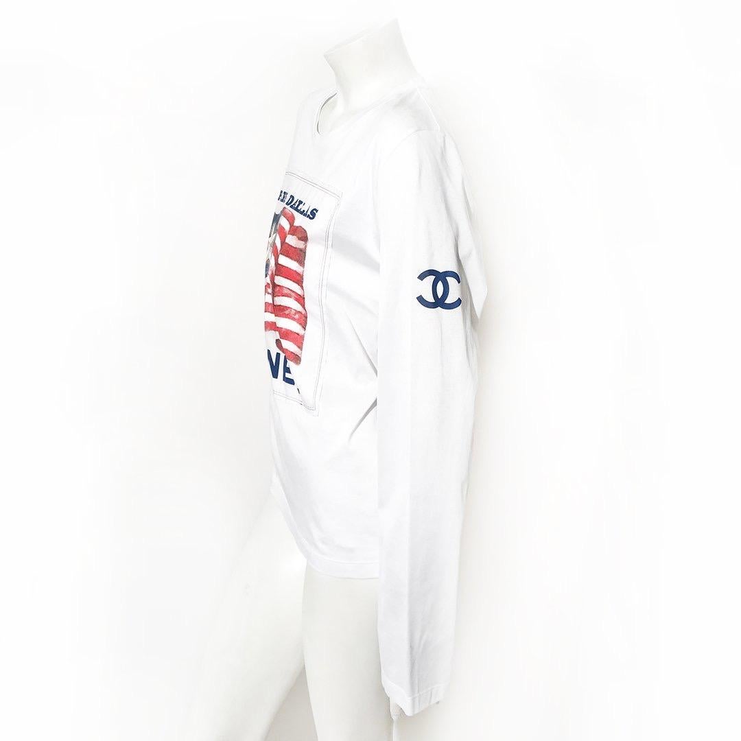 Paris-Dallas Flag Tee by Chanel 
Pre-Fall 2014 (VIP gift)
White long sleeve
Paris-Dallas Chanel flag graphic on front
CC on left shoulder
100% cotton
Condition: Excellent, no visible wear
Size/Measurements: (approximate, taken flat) 
Size Large 
40