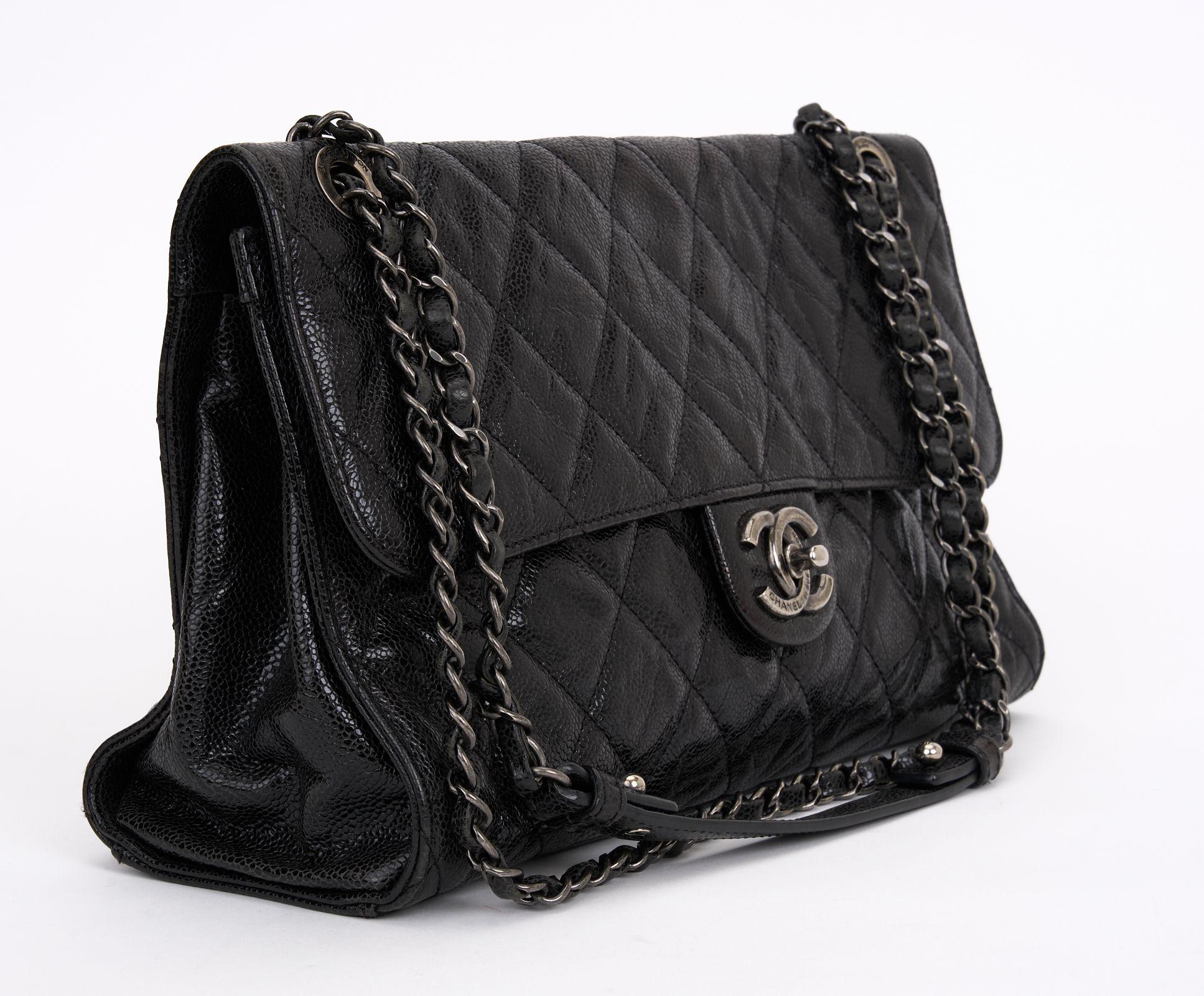 This Chanel Paris-Edinburgh Crave flap bag in black and Ruthenium hardware with rouge interior features, an interlocking CC Logo, a quilted pattern and chain link shoulder straps, a turn lock closure, and three interior pockets. Comes with hologram