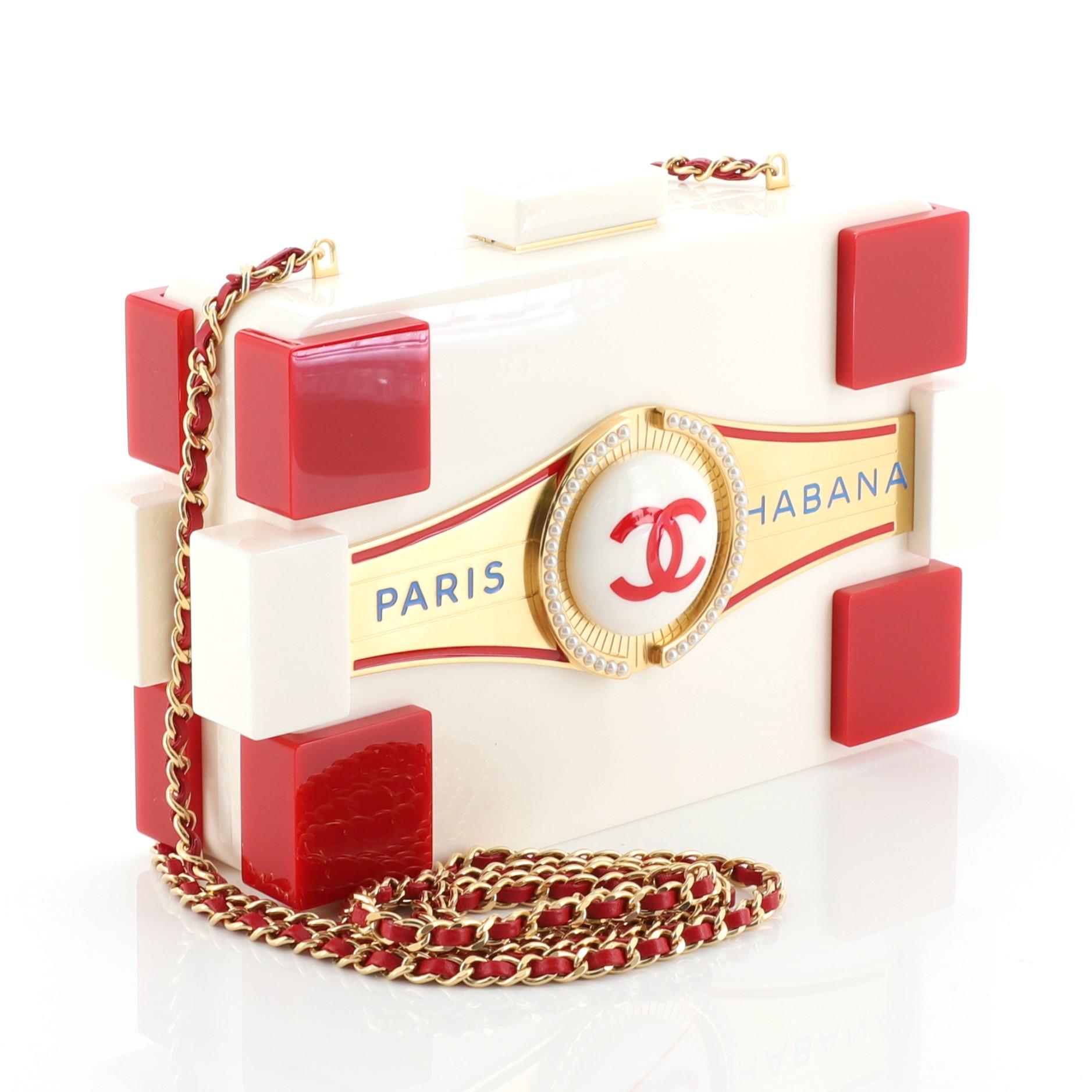 This Chanel Paris-Habana Lego Clutch Plexiglass, crafted from red and white plexiglass, features chain link strap, CC logo at the front, and matte gold tone hardware. It opens to a gold leather interior. Authenticity code reads: 23525249.

Estimated