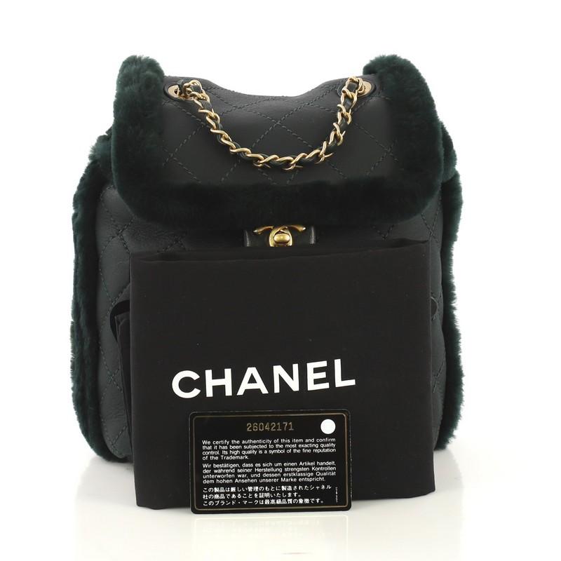 This Chanel Paris Hamburg Flap Backpack Quilted Lambskin and Shearling, crafted in green quilted lambskin and shearling, features woven-in leather chain straps, exterior zip pocket and gold-tone hardware. Its flap and drawstring closure opens to a