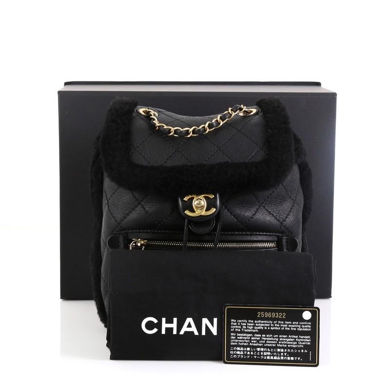 This Chanel Paris-Hamburg Flap Backpack Quilted Lambskin and Shearling, crafted in black quilted lambskin and shearling, features woven-in leather chain handle, leather straps, exterior zip pocket and gold-tone hardware. Its flap and drawstring