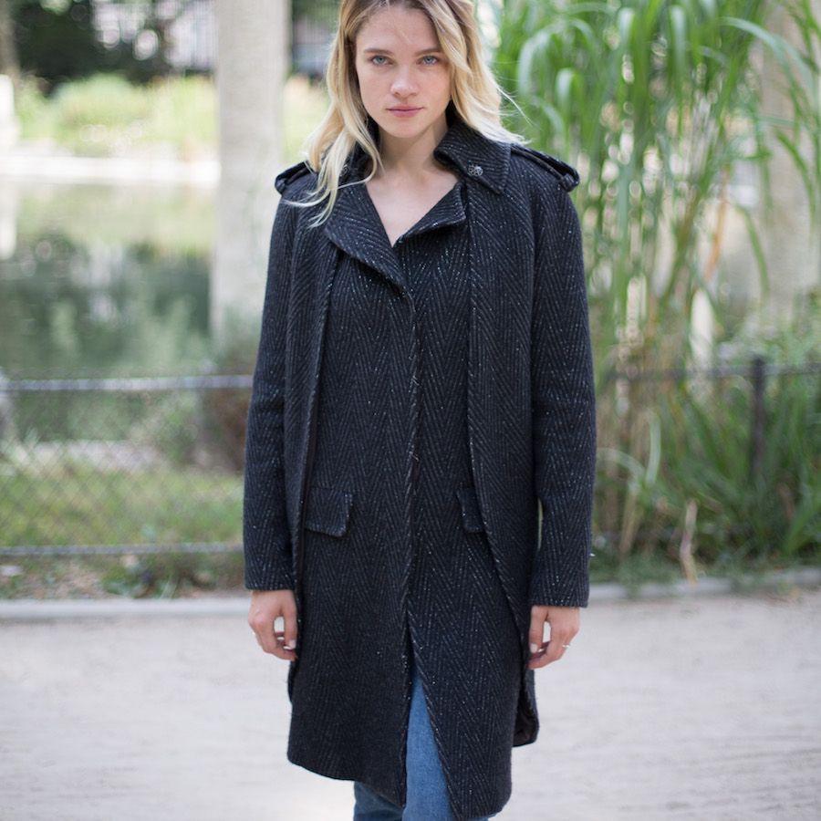 CHANEL woolen cape coat with gray and black chevron patterns and raglan sleeves from the Fall / Winter 2008-2009 Paris-Moscow Métiers d'Art Collection. 
The coat has an officer collar, it is sleeveless but covered by its cape. There are two pockets