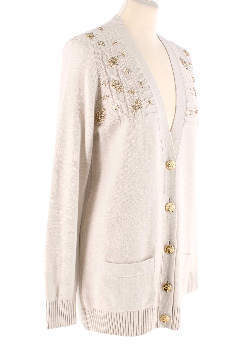 Chanel Paris/Rome Cashmere Embellished Cable Knit Cardigan
 

 -CHANEL cardigan comes in a cream cashmere knit with a ribbed crewneck, patch pockets, unique cable knit textured panels with gold beads as well as gold tone Paris A Rome coin buttons.
