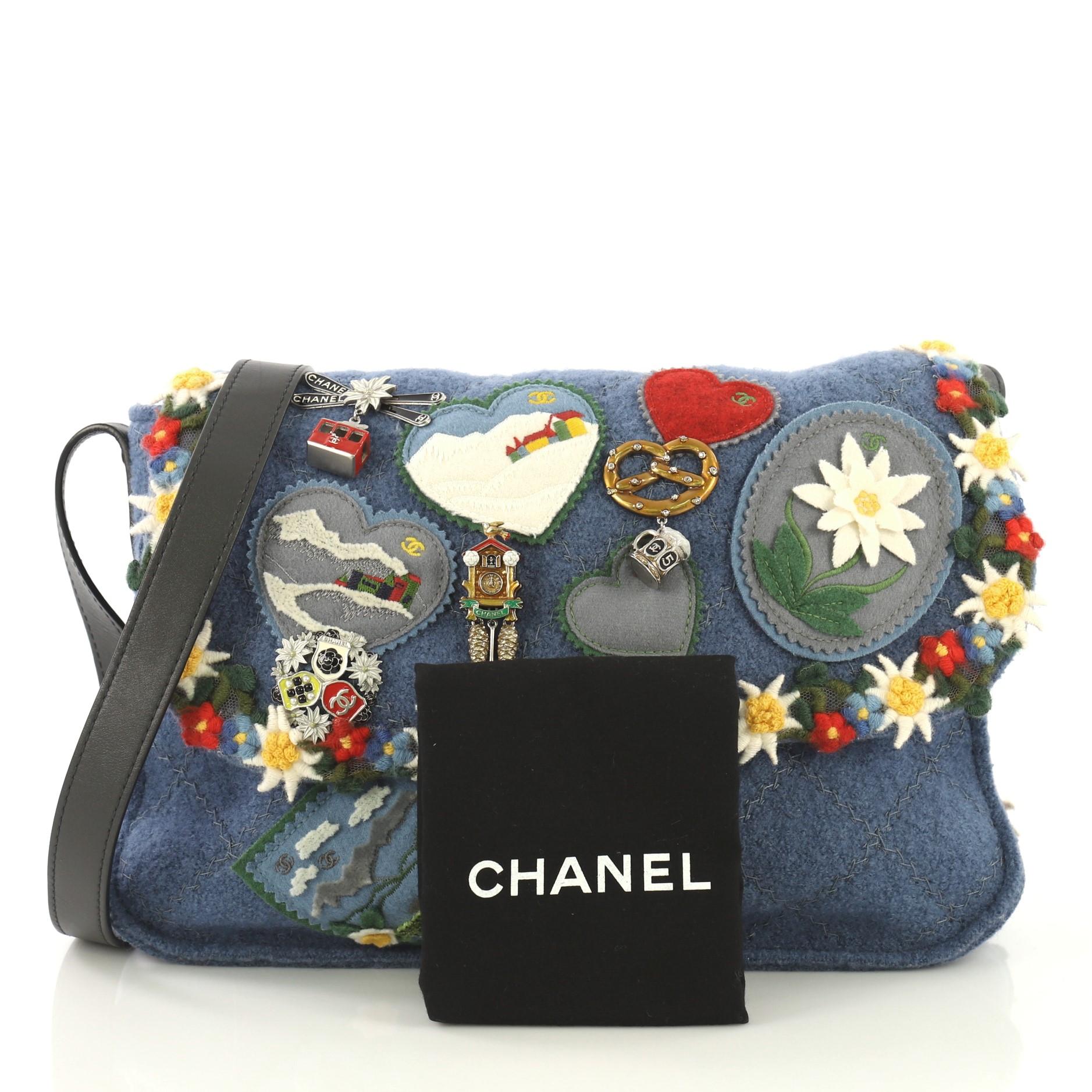 This Chanel Paris-Salzburg Crest Austrian Messenger Embroidered Felt Small, crafted from blue embroidered felt, features adjustable leather strap, patches and metal charms, and aged silver-tone hardware. Its flap opens to a gray fabric interior with