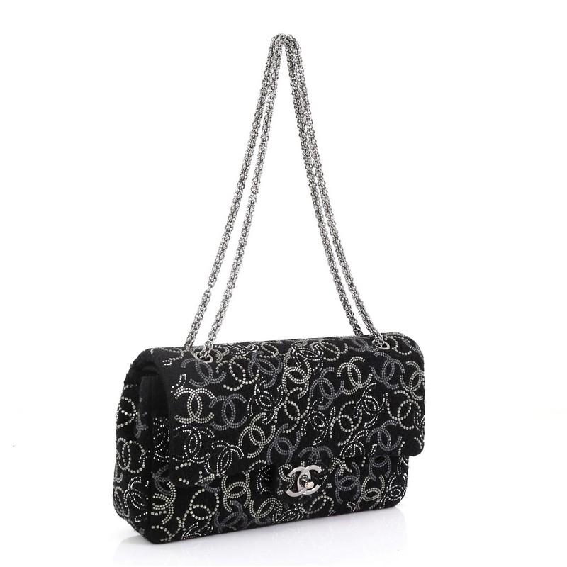 This Chanel Paris-Shanghai Pudong Flap Bag Strass Embellished Tweed Medium, crafted from black strass embellished tweed, features chain link shoulder strap, strass CC logo embroidery throughout, and gunmetal-tone hardware. Its CC turn-lock closure