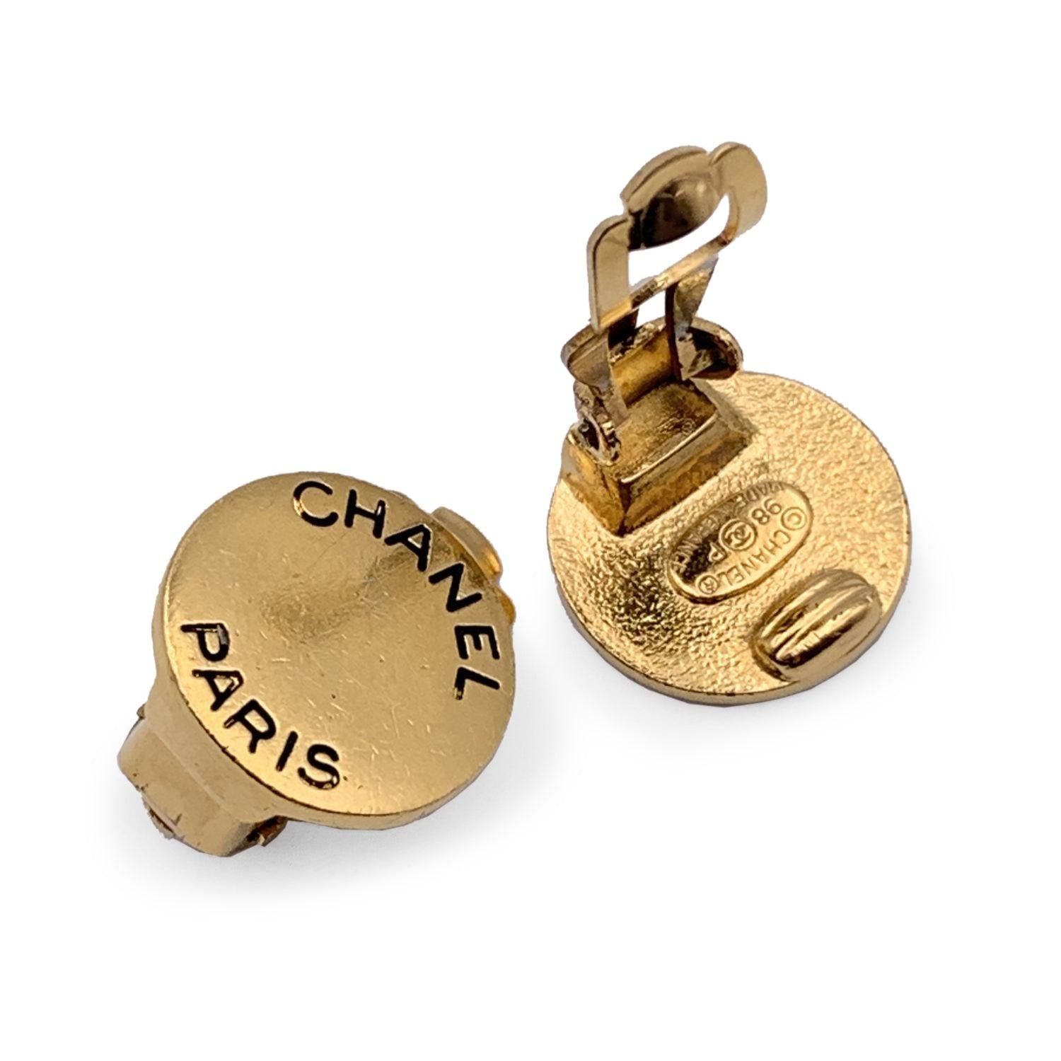 Beautiful vintage small round clip on earrings by CHANEL. They are finely crafted in gold metal with engraved 'Chanel Paris' logo. Clip on closure on the back. 'CHANEL - 98 CC P - Made in France' oval tag on the reverse of the earring. Width: 15 mm