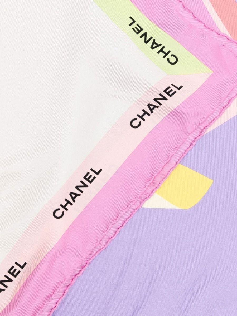 Displaying a simplistic array of classic Chanel bags in vibrant shades of yellow, purple, and blue. This pre-owned silk scarf has been finished with a border of Chanel's famous logo, wear it around your neck or in your hair.

Colour: