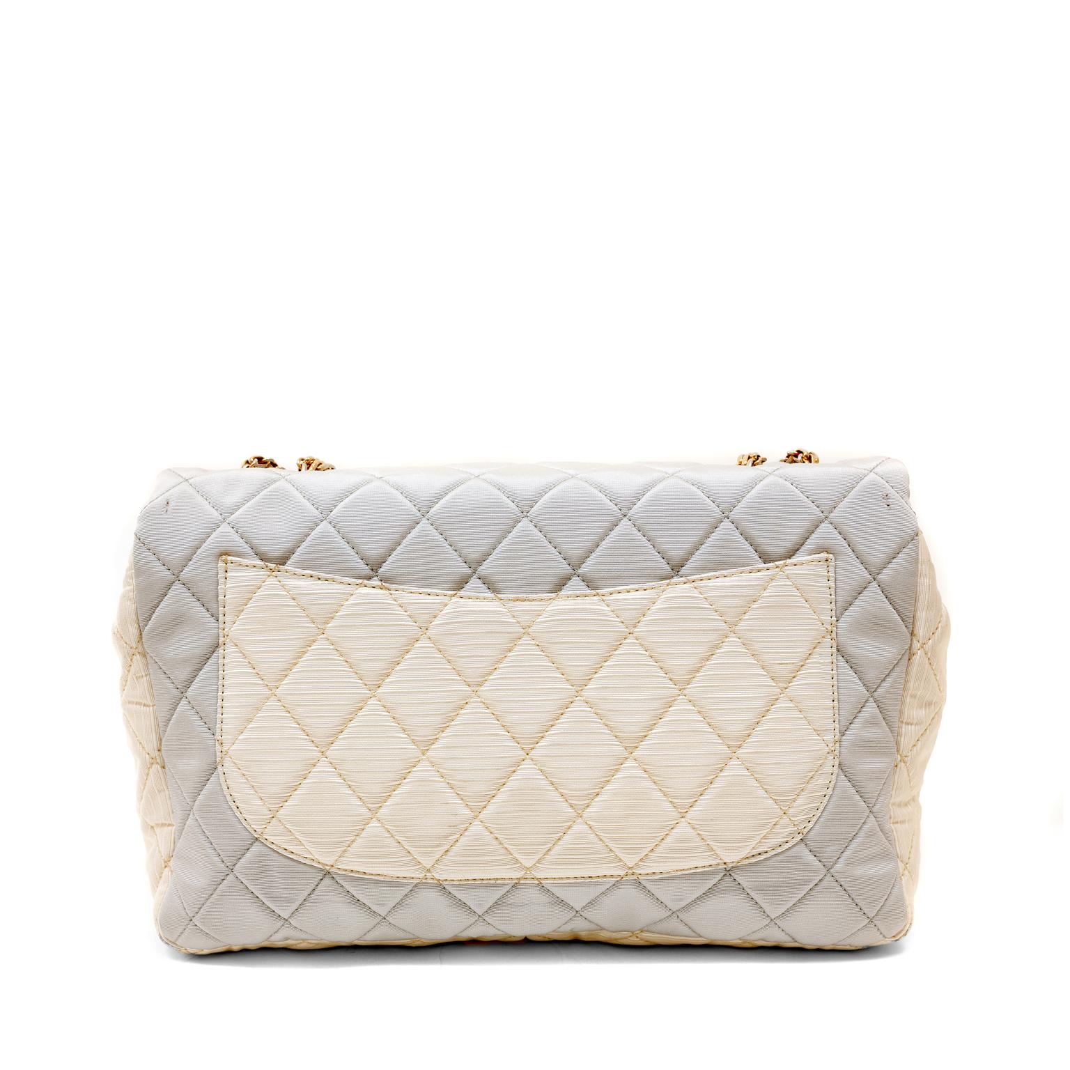 This authentic Chanel Tricolor Fabric Reissue Flap Bag is in excellent condition.  It is a beautiful version of the iconic reissue in feminine pastel colors.
Grosgrain fabric is quilted in signature Chanel diamond pattern in shades of pale powder