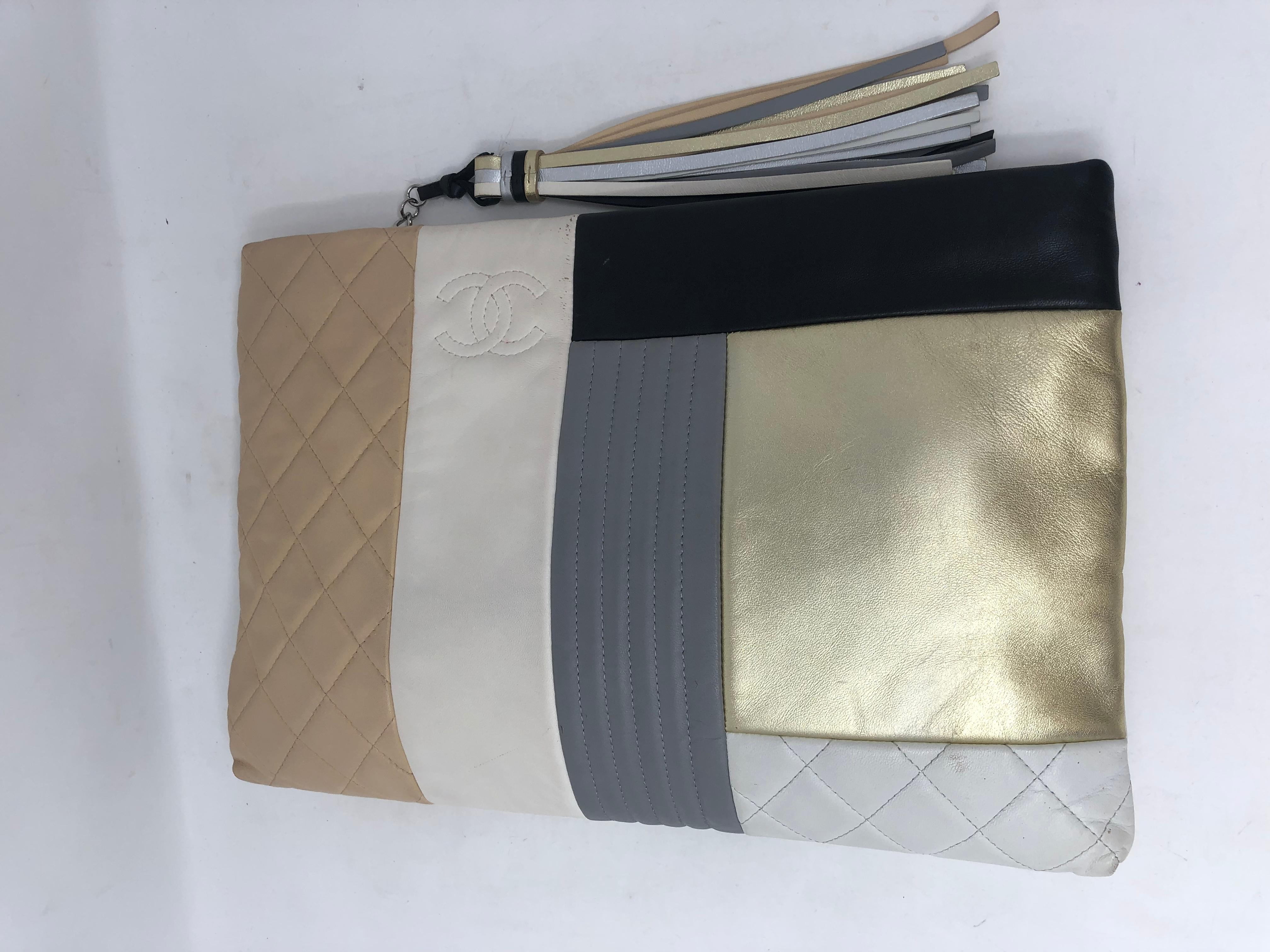 Chanel Patchwork Clutch with Tassel. Silver metallic clutch with strips of leather woven through the bag. Multicolor clutch that is limited and unique. Has some wear but lots of life left. Guaranteed authentic. 