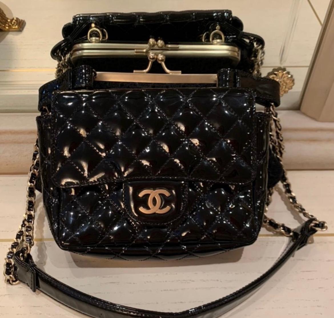 CHANEL PATENT AND LACE TWIN CHAIN SHOULDER BAG BLACK.
This is a pre-owned Chanel Twin Chain Shoulder bag. It is black patent leather with black lace and gold hardware. It measures at 6.5″x4″x5″ drop:13.5″. It is in excellent condition. Includes dust