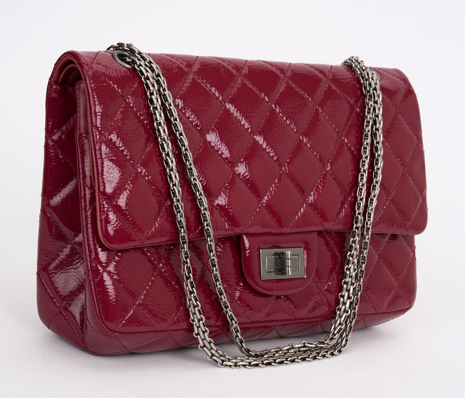 Classic Chanel 2.55 shoulder bag in red patent leather with silver hardware, features a chain strap in silver metal allowing the bag to be worn in the hand or on the shoulder, a Mademoiselle turn lock closure on the flap, a patch pocket at the back,