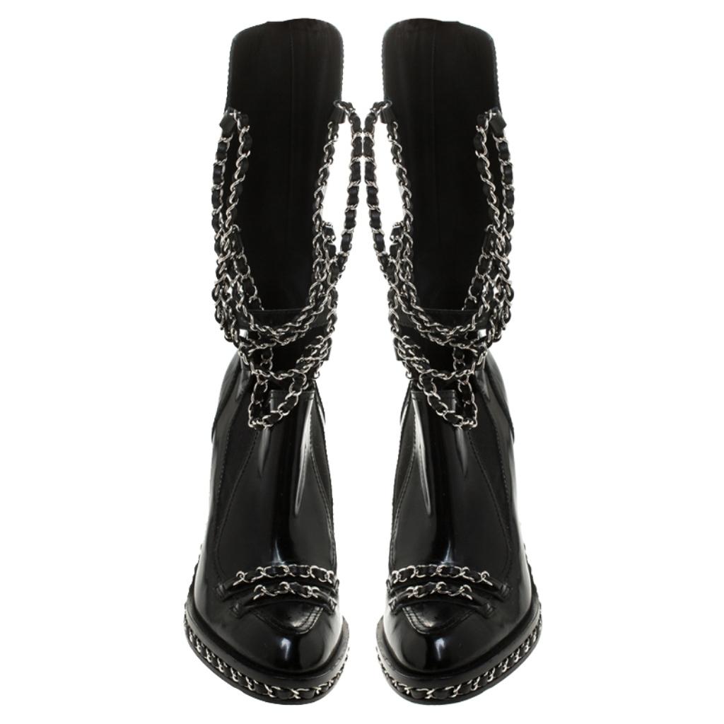 This season get these boots by Chanel and take your fashion quotient to new heights. Made from patent leather, these black boots are one-of-a-kind. They feature the signature interwoven chain on the base & uppers and also act as laces that keep the