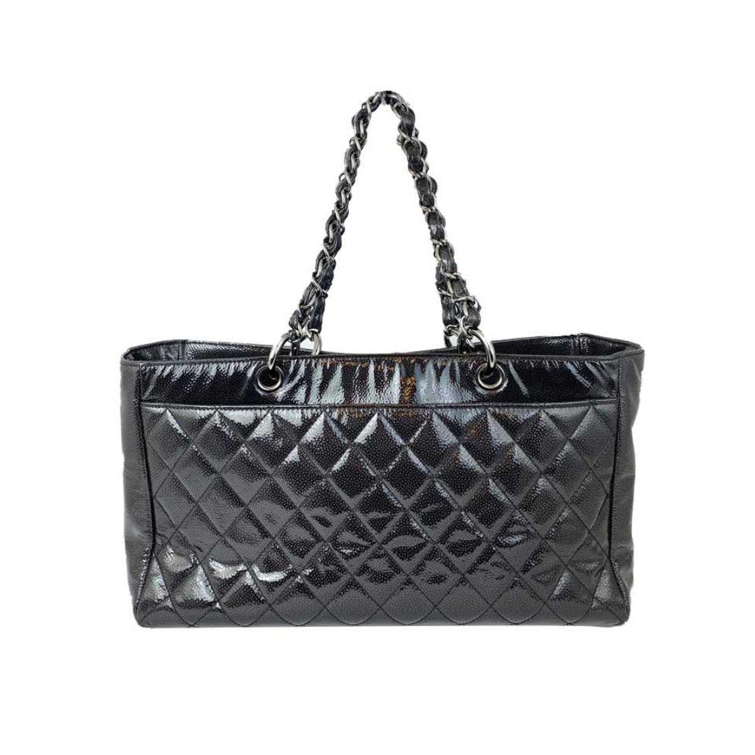 Make a sophisticated statement with this Chanel black patent leather quilted tote. Featuring the iconic diamond quilting and high-shine patent finish, this timeless piece is both functional and fashionable. The chunky leather-woven chain straps and