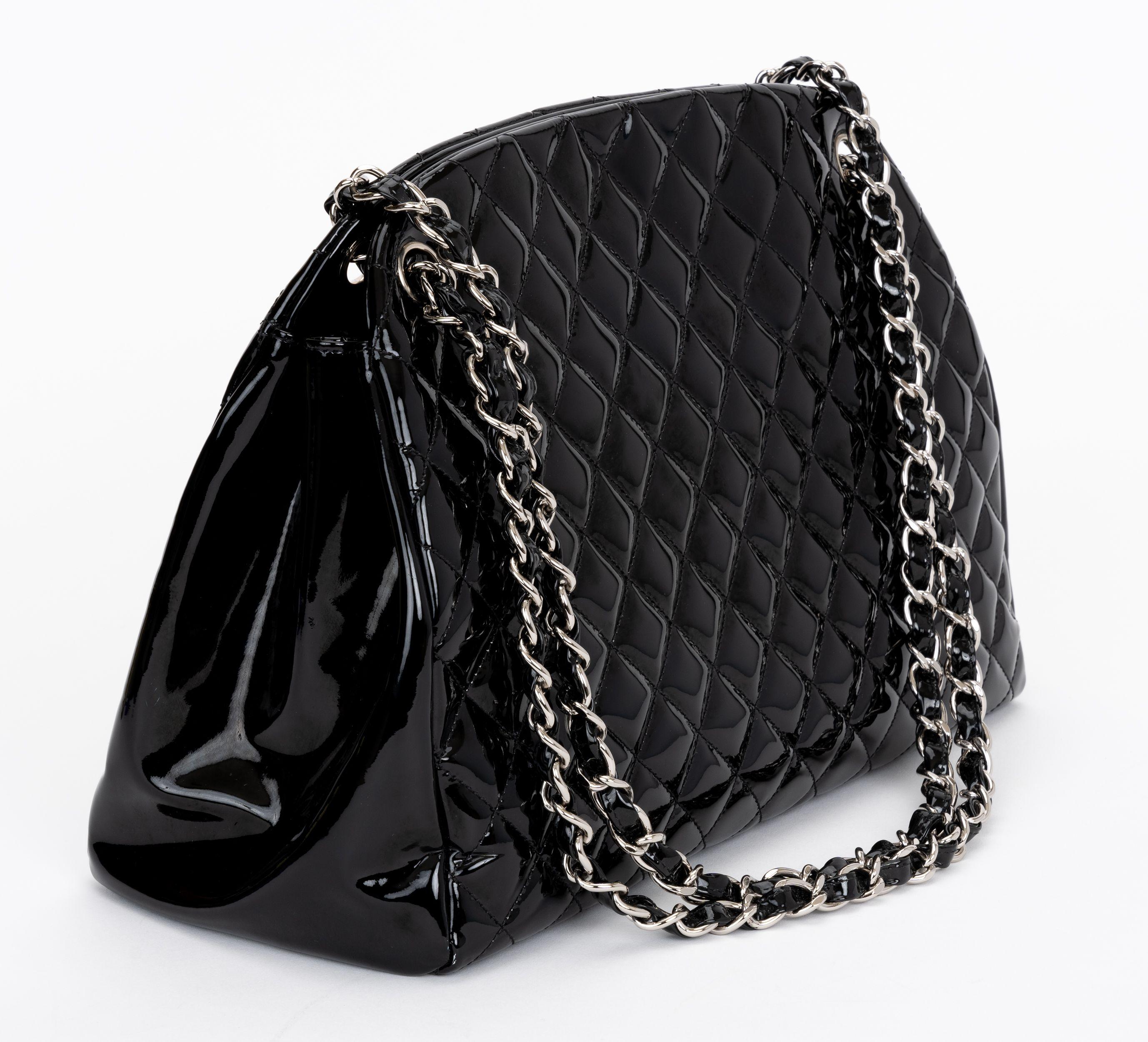 The Chanel Quilted Leather Just Mademoiselle Bowling Bag features durable quilted patent leather in the signature diamond stitch pattern with interlocking silver CC logo charm. The bag has a middle compartment that closes with a zipper. 

Shoulder