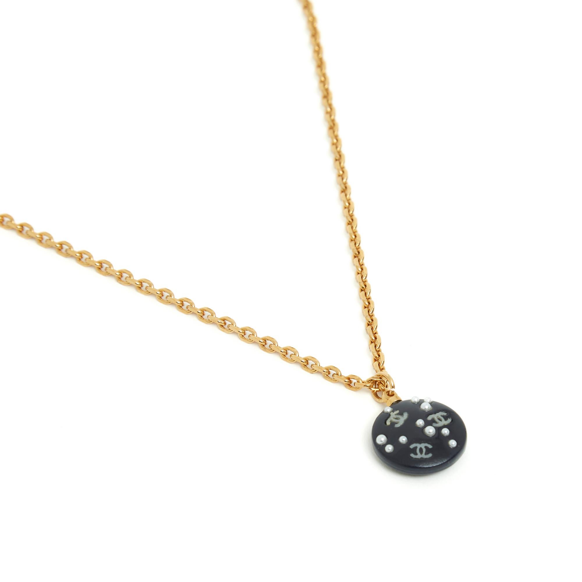 Collana Chanel della collezione Primavera Estate 2003, composta da una catena a maglie in metallo placcato oro e da un medaglione in plastica blu navy, quasi nero, intarsiato con piccole perle fantasia di diverse dimensioni e piccole CC in oro