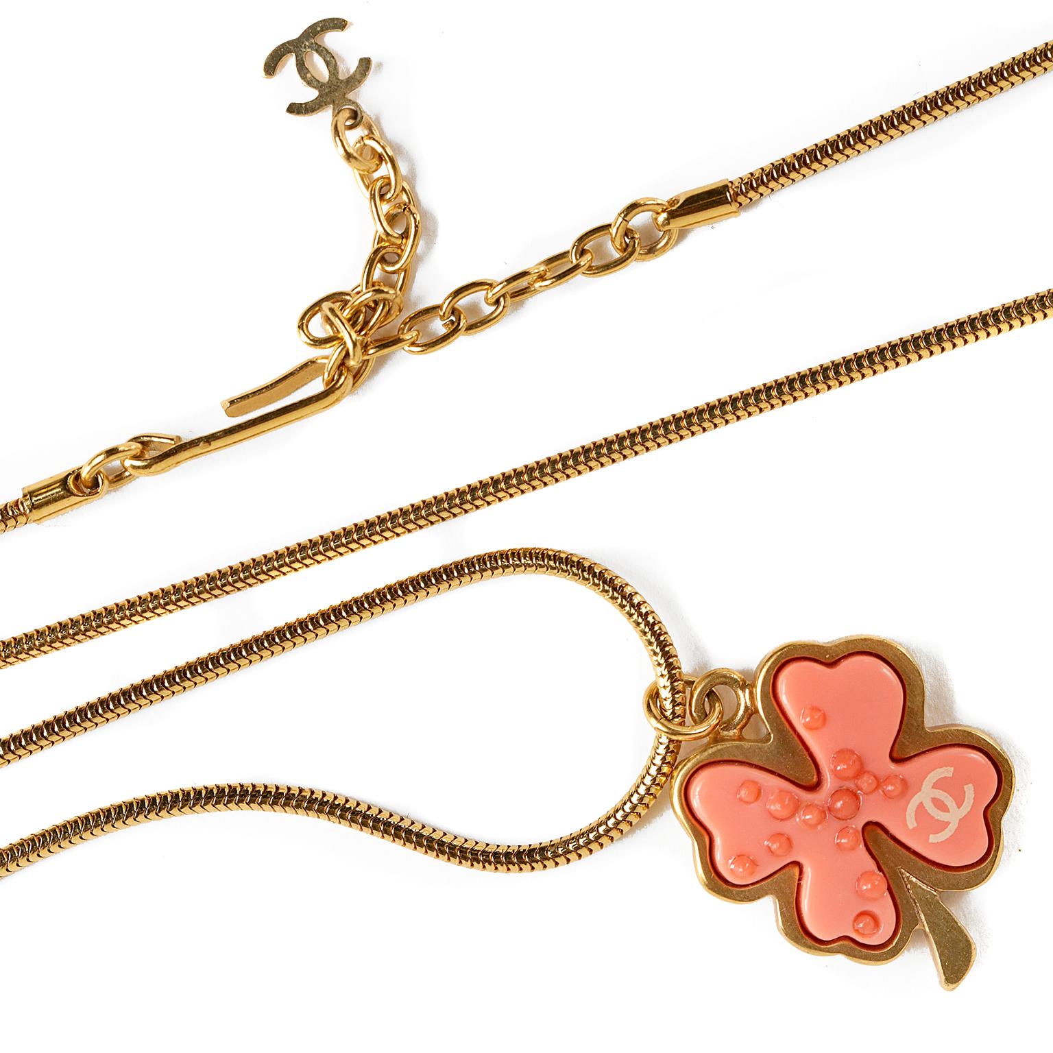 This authentic Chanel Coral Clover Necklace is in excellent condition from the 2005 collection.  Coral clover shaped pendant dangles from a long gold snake chain.  Adjustable length with hook closure.  Measures approximately thirty-one inches end to