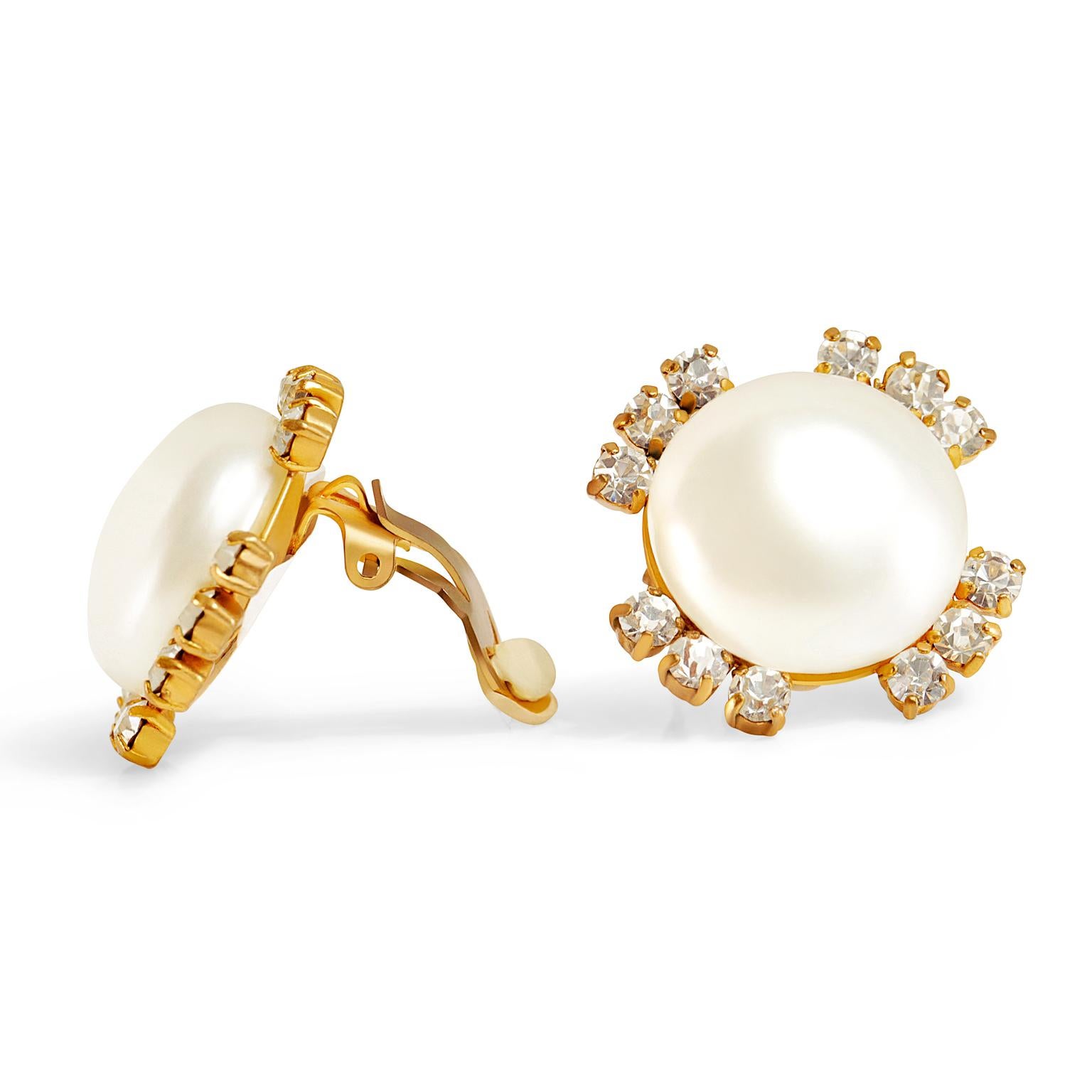 These authentic Chanel Pearl and Crystal Earrings are in excellent condition.  Large round faux pearl with gold surround and twelve crystal embellishments form a simple flower. Clip on closure. Made in France.

